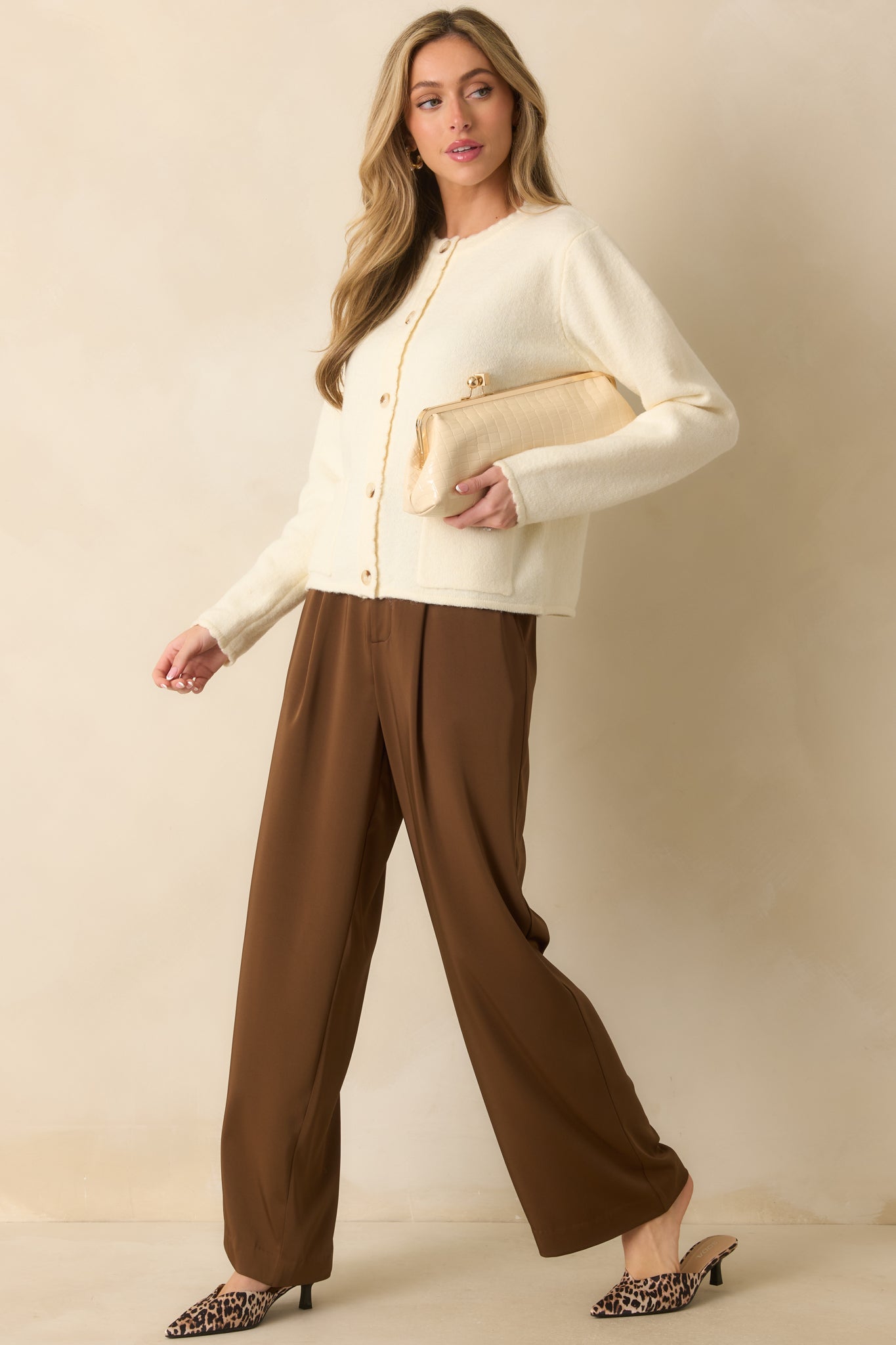 Wide-leg brown trousers featuring functional side pockets, zip fly with hidden hook closure, and smooth drape.
