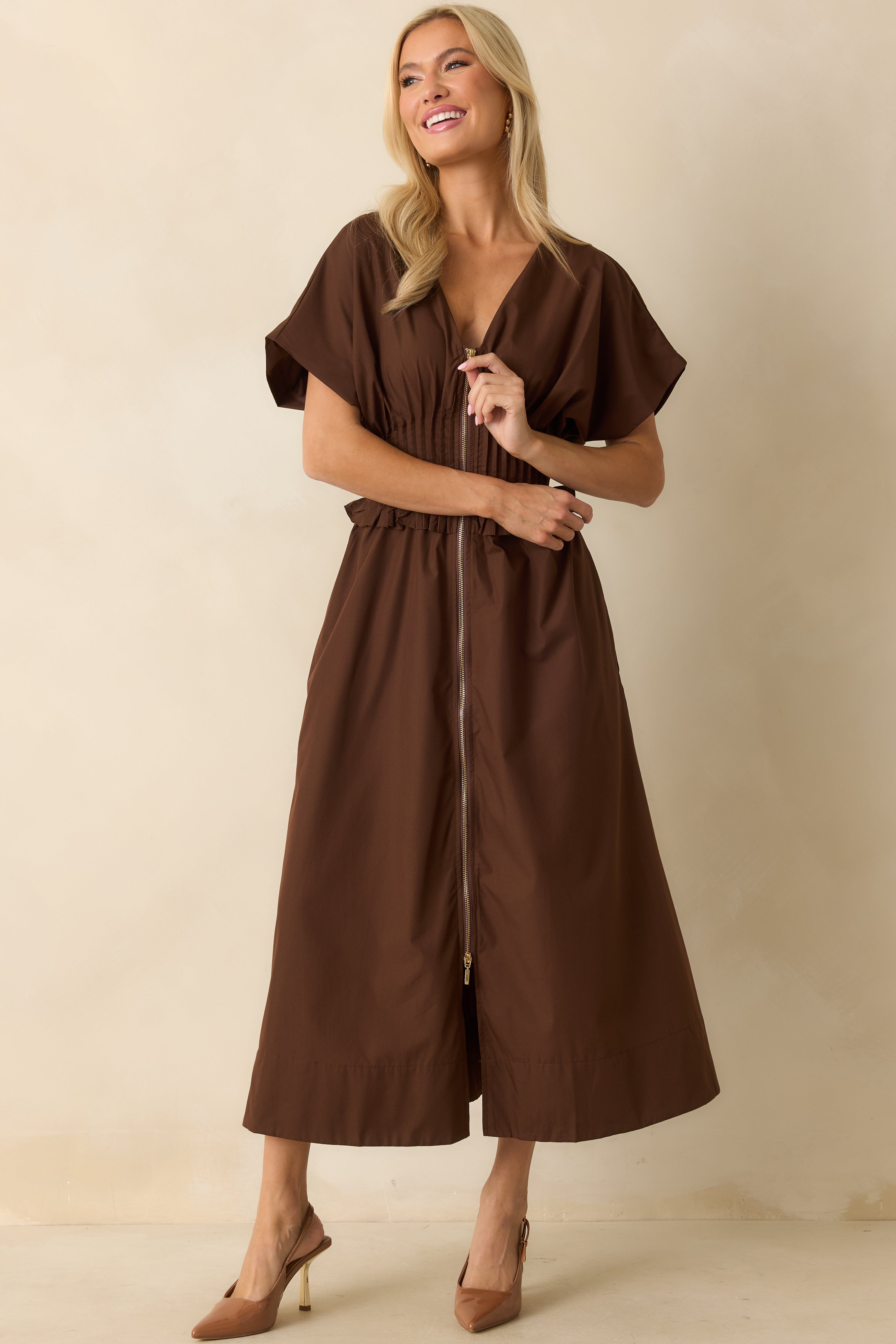 Brown woven dress featuring a front zip closure and relaxed silhouette flowing from the ruffled waist detail.