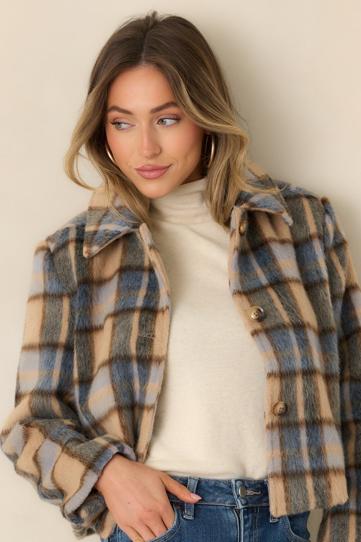 Warm toffee and muted blue tones blend across the jacket’s soft brushed fabric.