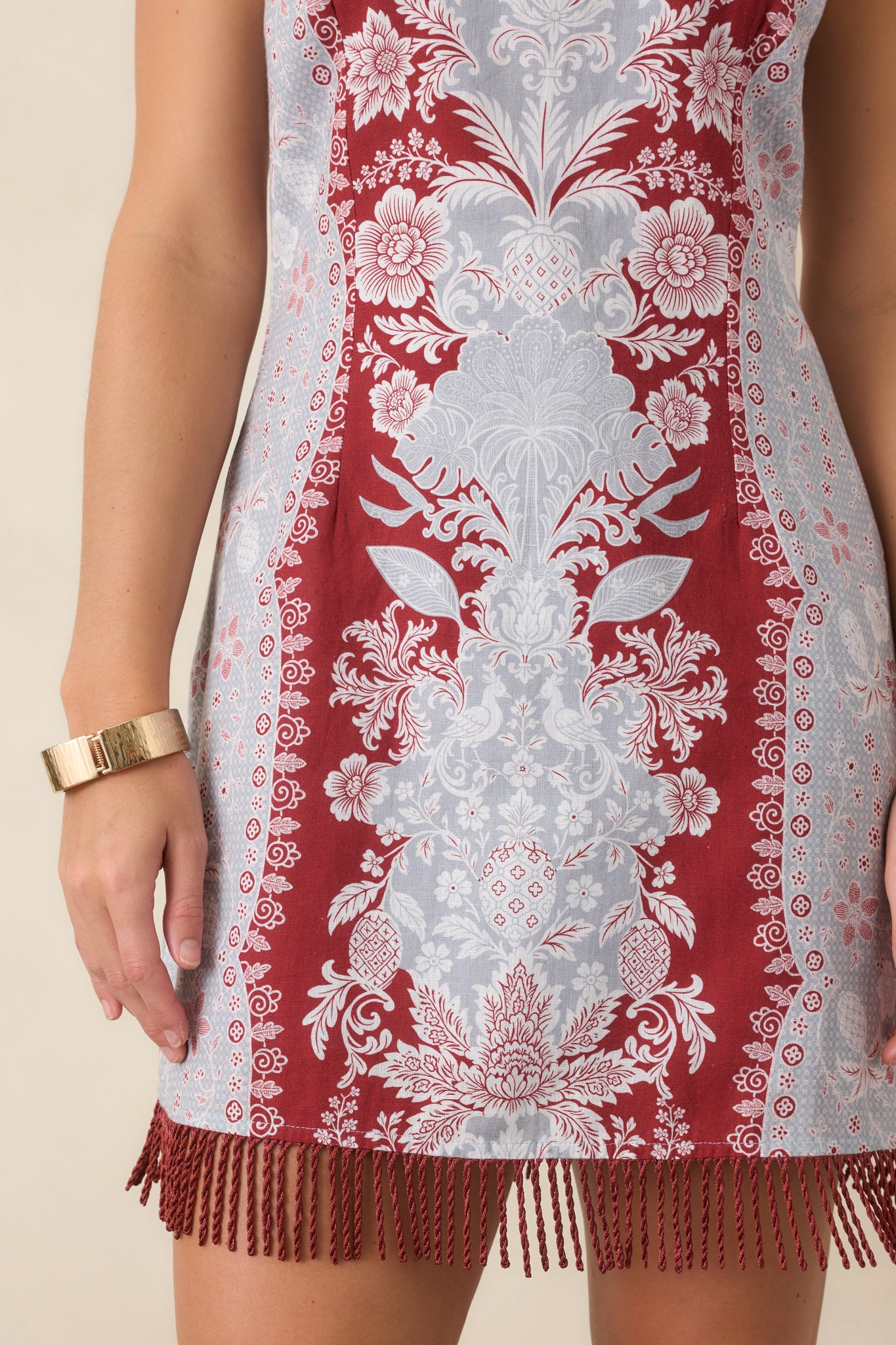 Close-up of the burgundy, icy blue, and ivory border print along the hem, finished with fringe trim for added texture and movement.
