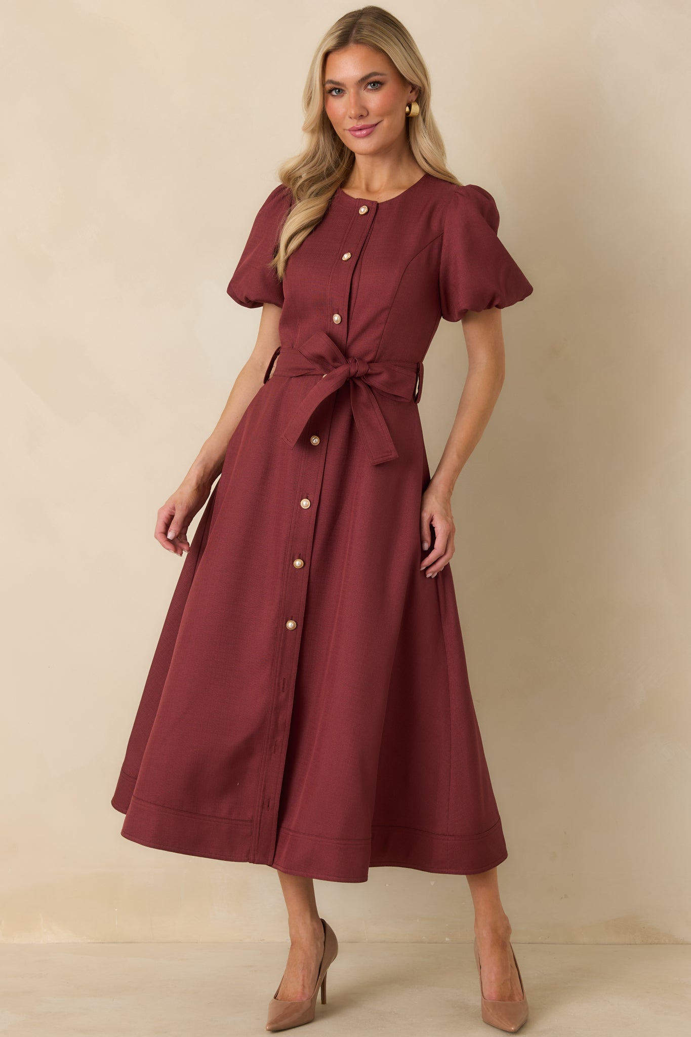 Burgundy button-front midi dress with voluminous short puff sleeves, a fitted bodice, tied waist, and sweeping skirt.