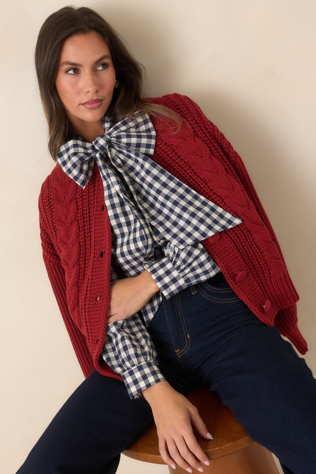 Chunky cable detailing adds dimension to the burgundy cardigan front.