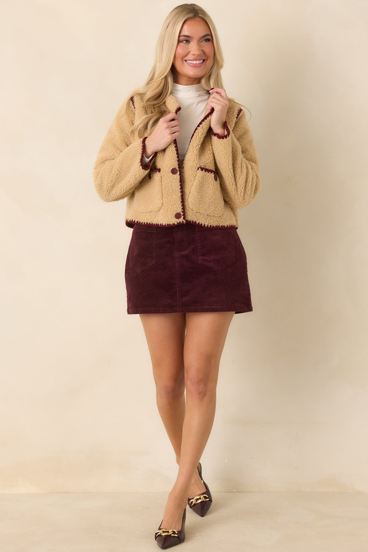 Rich burgundy mini skirt featuring fine corduroy ribbing, a small coin pocket, and built-in shorts.