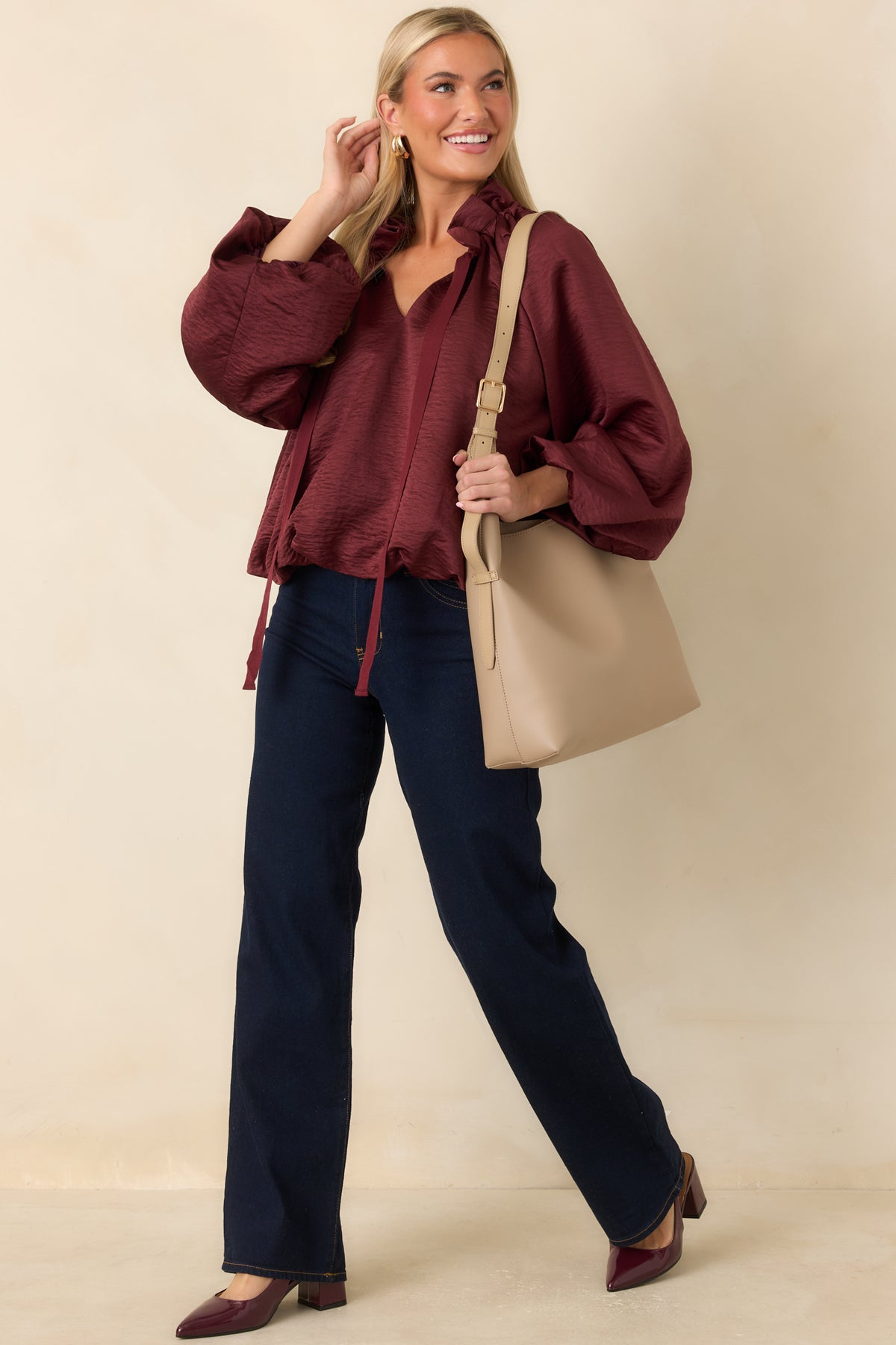 Burgundy top with a softly crinkled sheen, ruffled stand collar, split V-neckline, and long balloon sleeves.