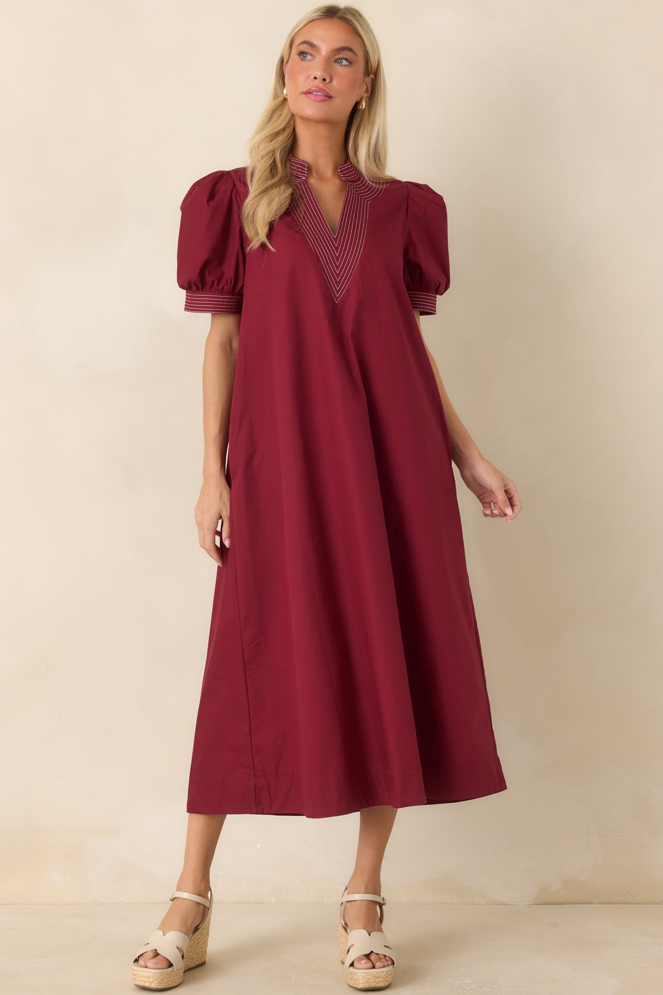 Burgundy dress showcasing graphic contrast stitching, puff sleeves, and a fully lined construction.