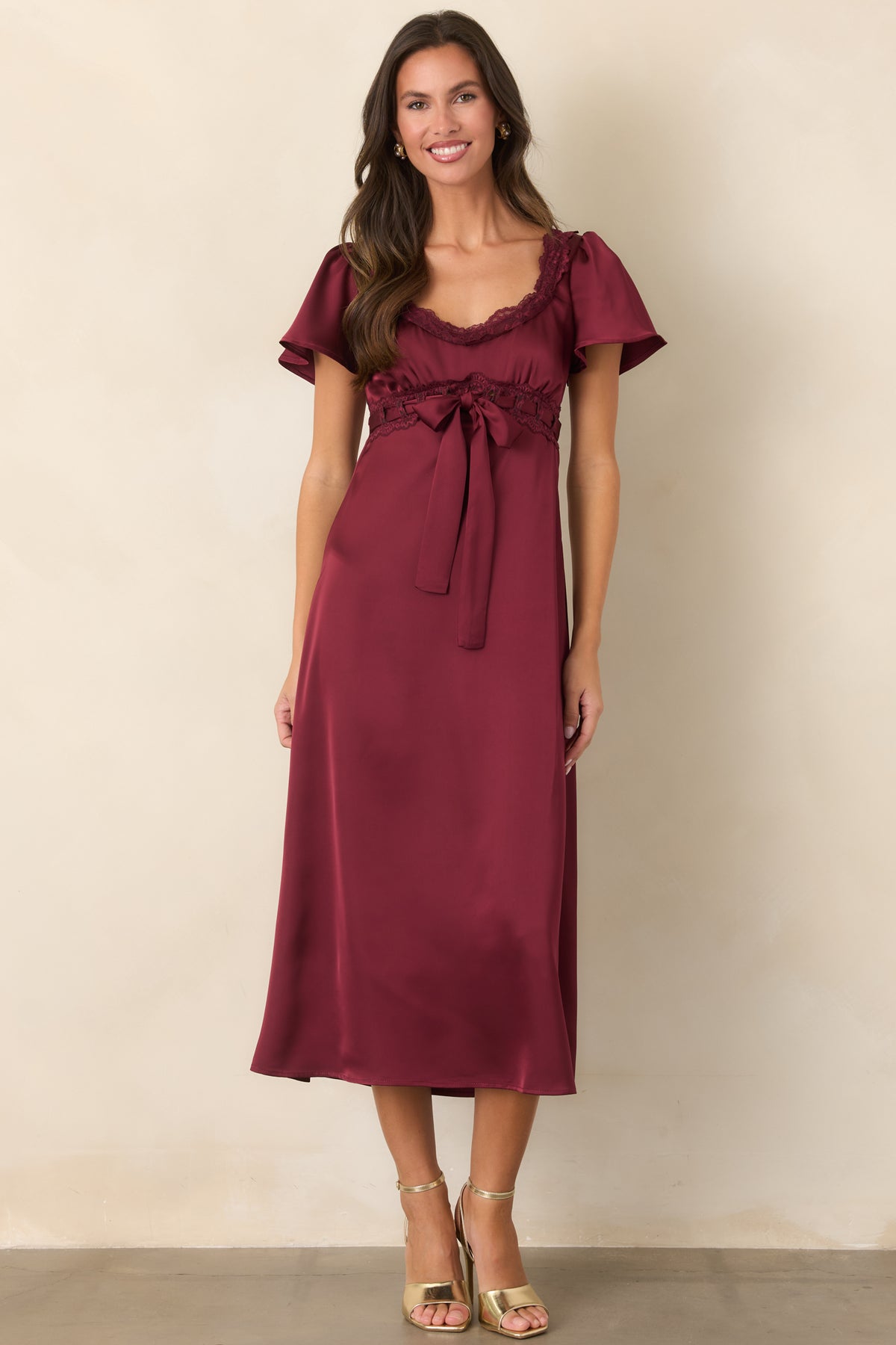 Burgundy midi dress with a romantic empire silhouette, lace-trimmed neckline, and delicate flutter sleeves.
