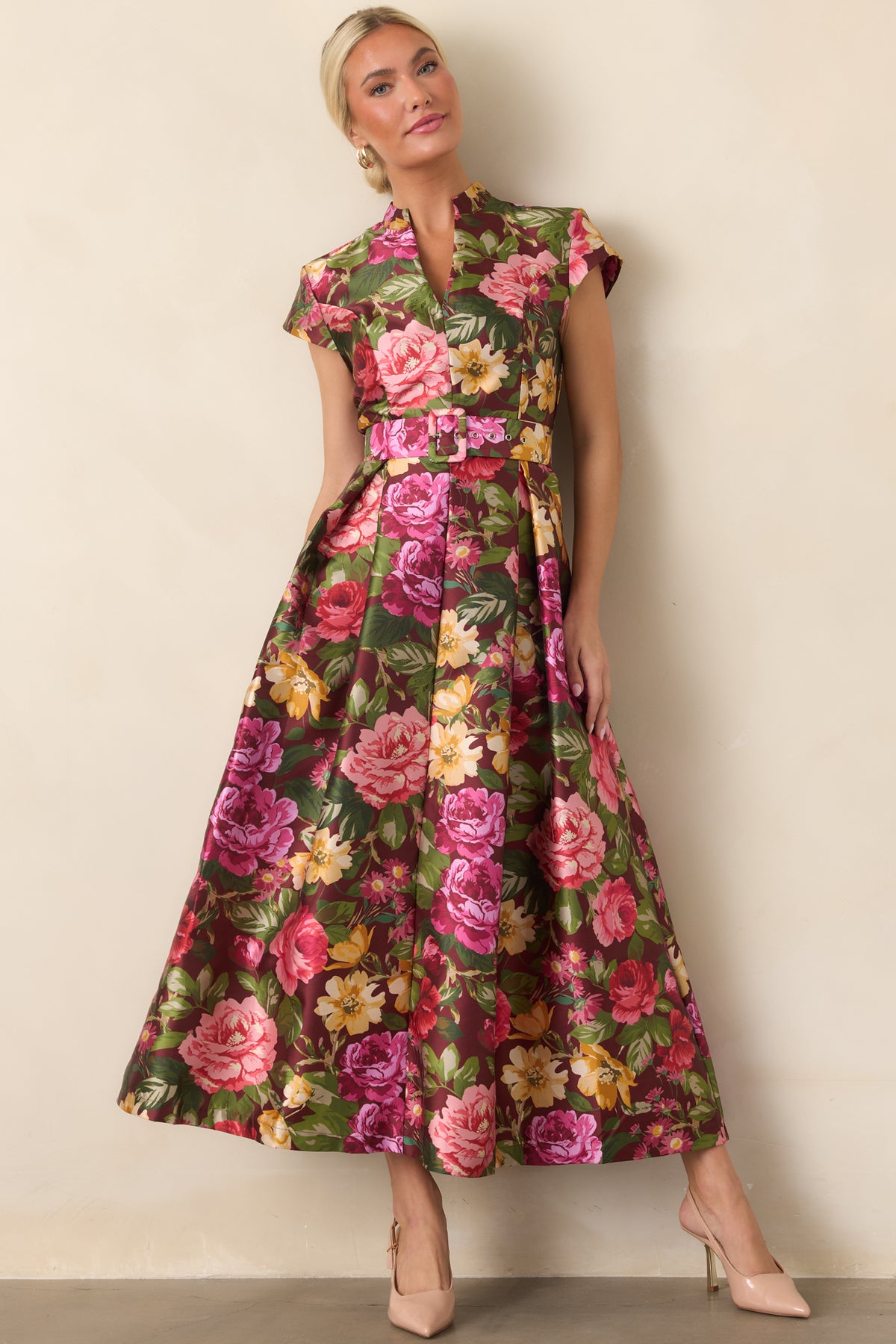 Burgundy floral dress emphasizing the colorful print, fitted bodice, removable waist belt, and pleated skirt.