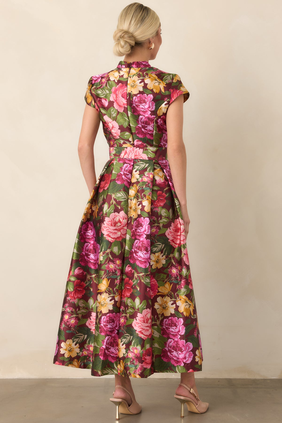 Rear view of the burgundy floral dress showing the defined waist, matching fabric belt, and pleated skirt.