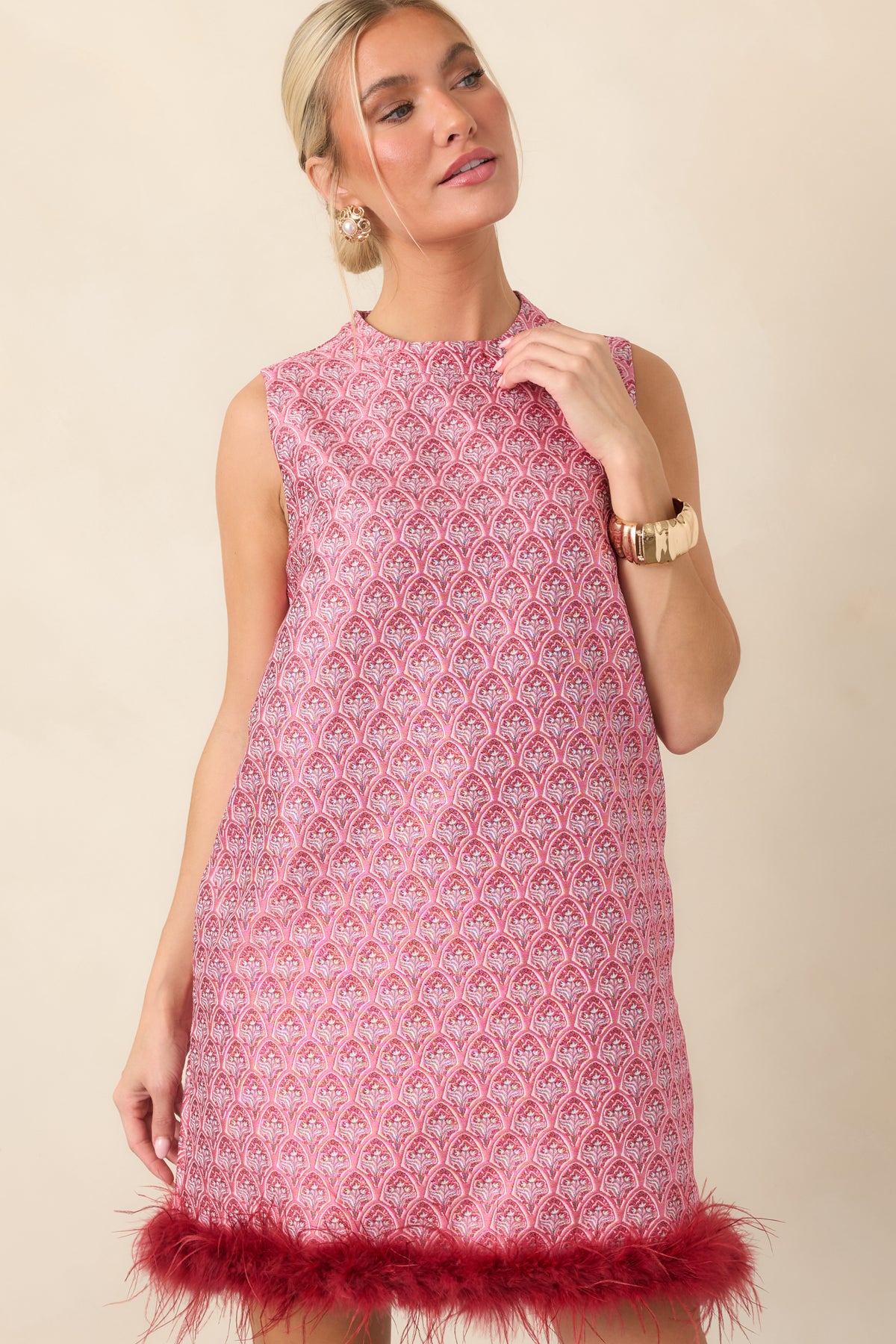 Burgundy feather trim adds texture and movement to the ornate floral mini dress.