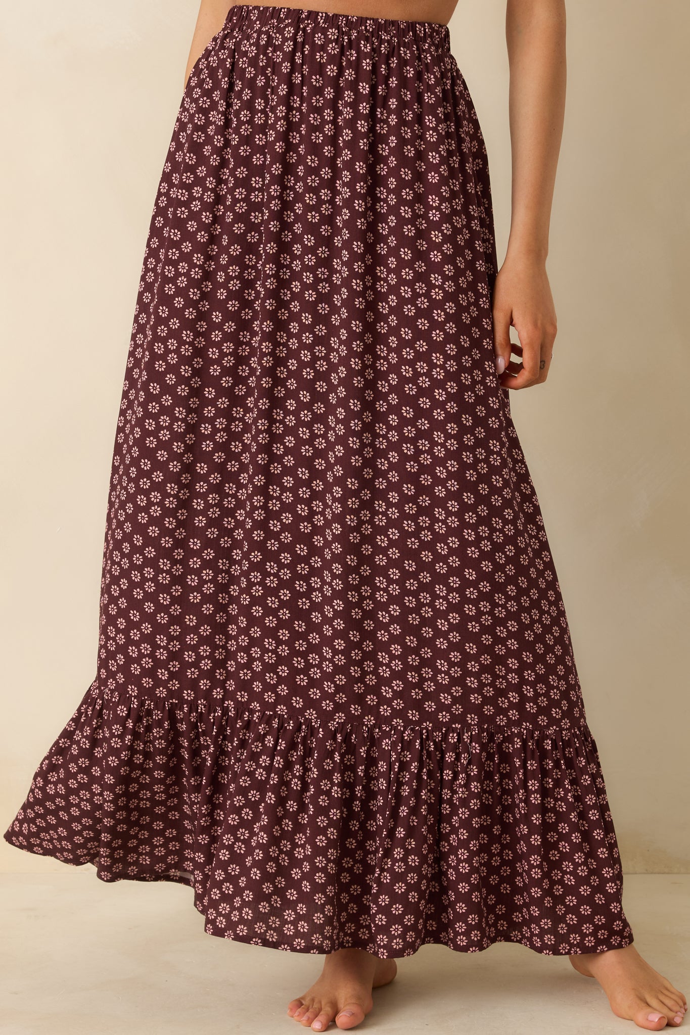 Burgundy floral skirt capturing the gentle flare of its A-line silhouette.