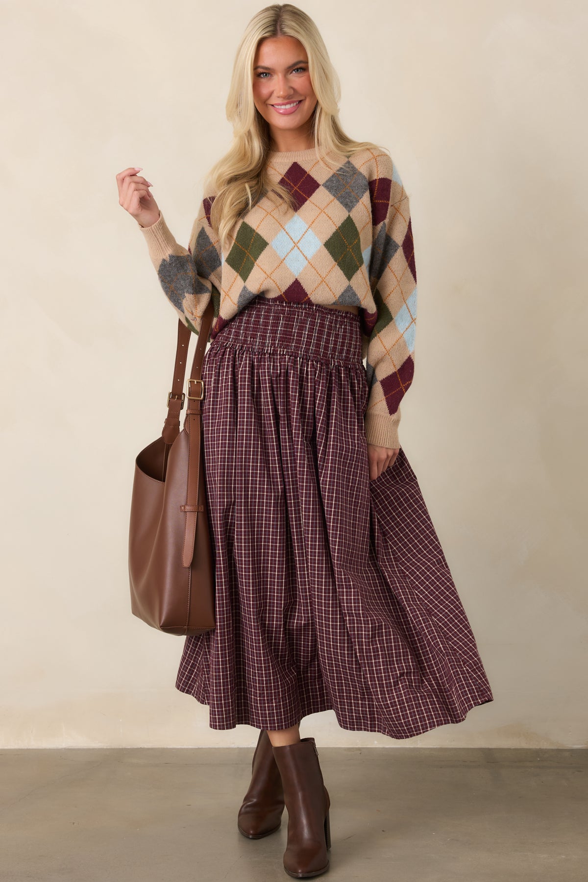 Burgundy, ivory, and light blue plaid maxi skirt with a wide smocked drop waist, ruffle trim, gathered full skirt, and side pockets.