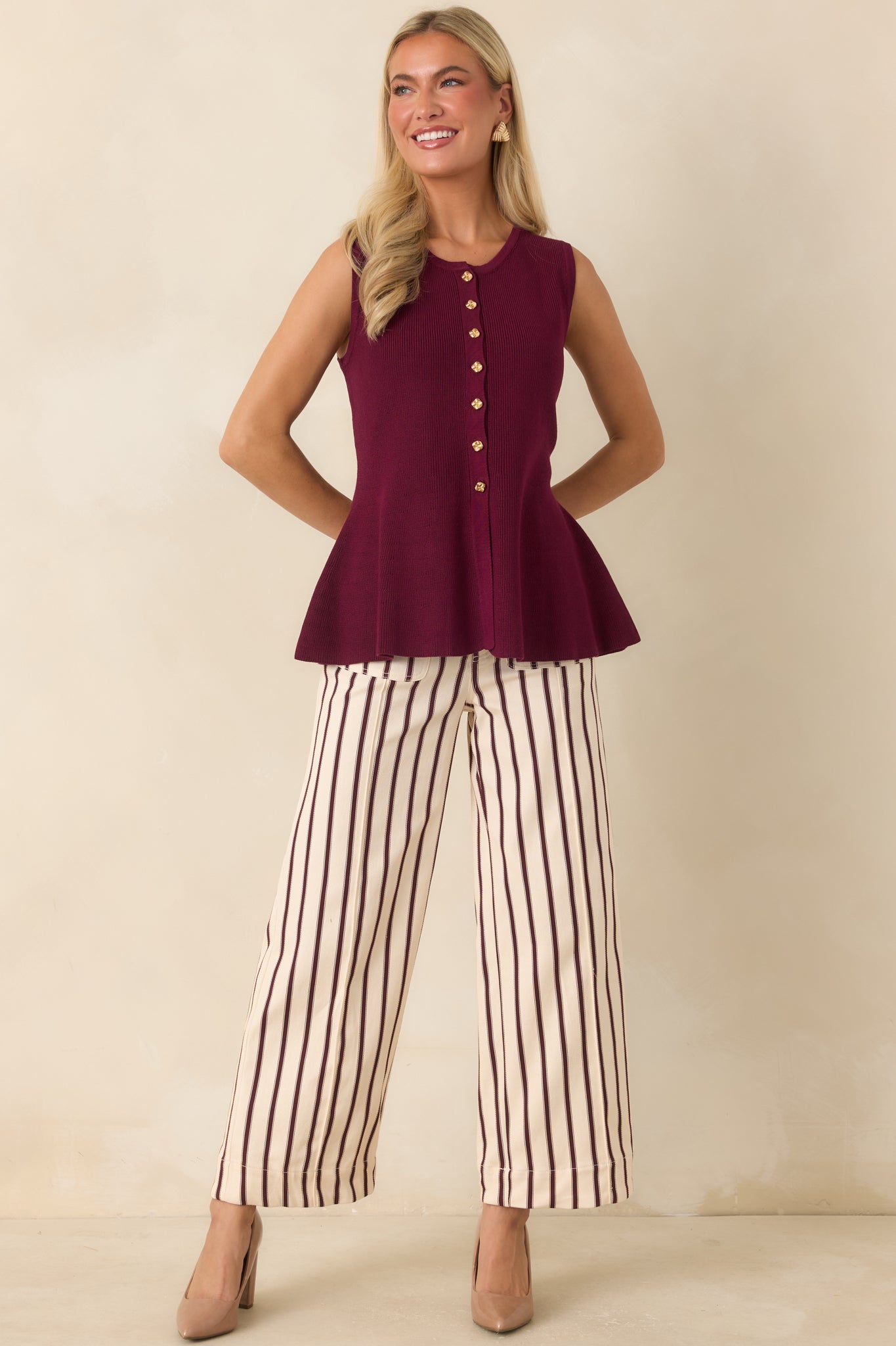 Burgundy and ivory striped high-rise pants featuring oversized front patch pockets, decorative buttons, and a relaxed wide-leg silhouette.