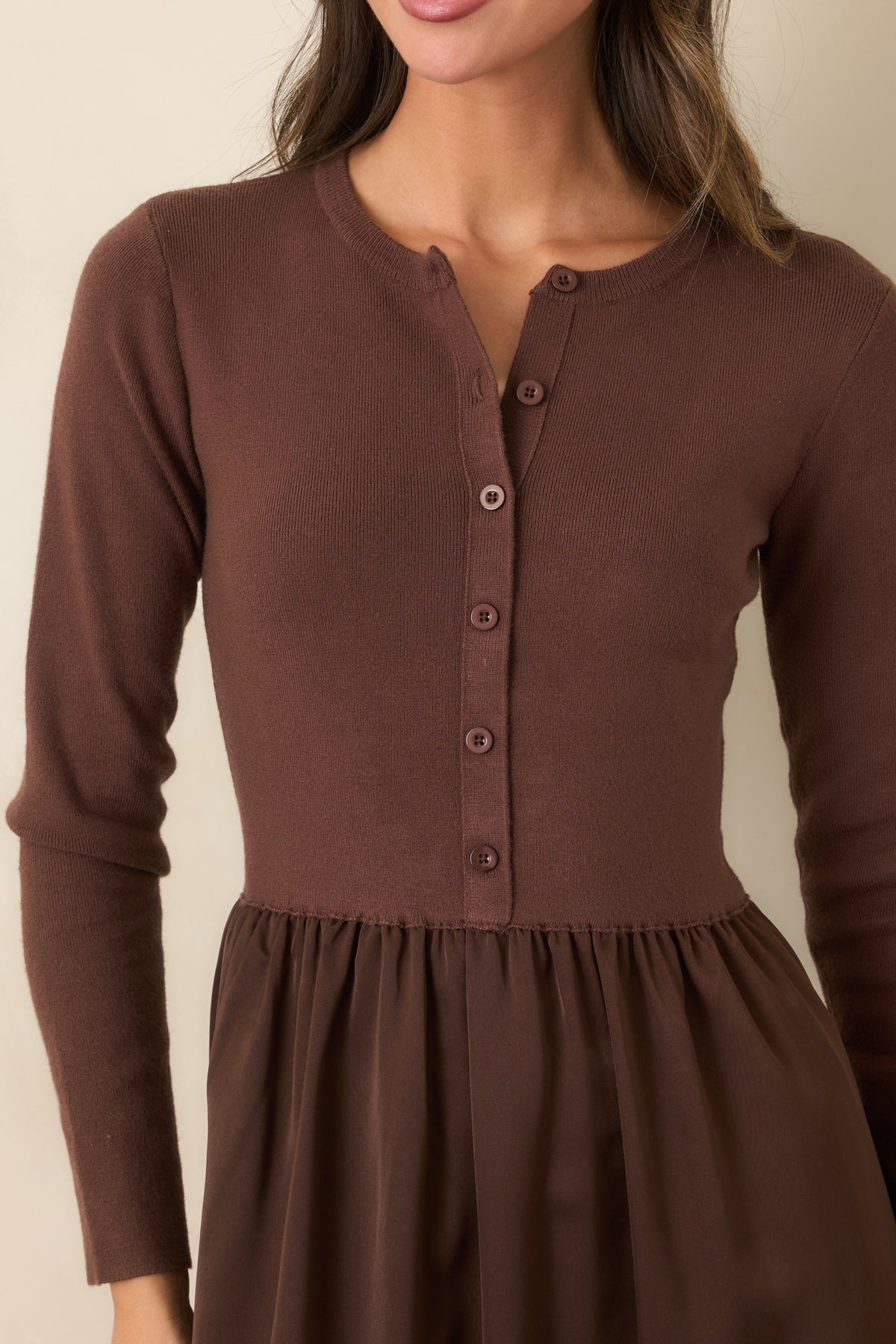 Close-up of the burgundy knit bodice with round neckline, tonal buttons, and gathered satin skirt.