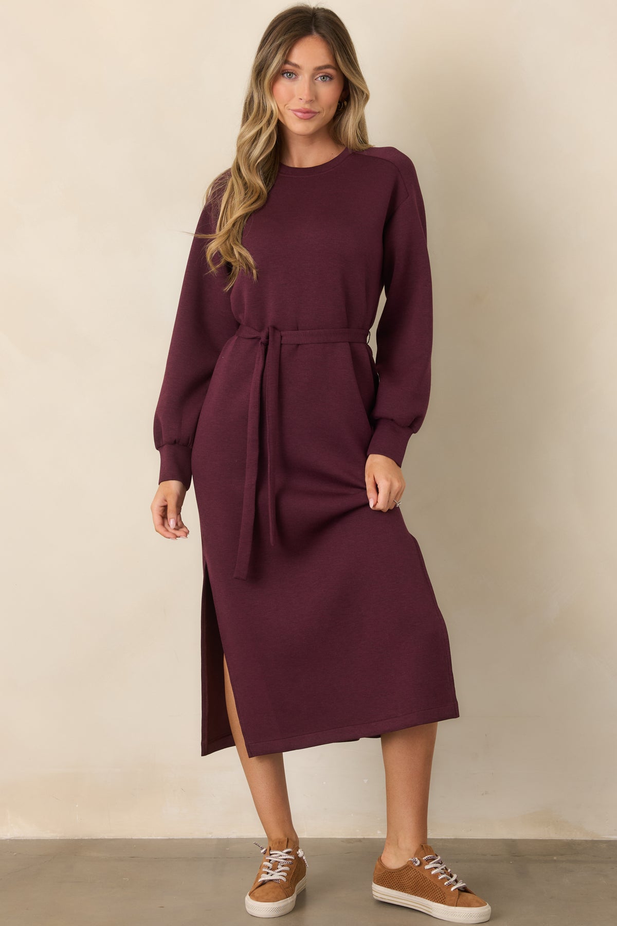 Burgundy long-sleeve midi dress featuring banded cuffs, a relaxed silhouette, and side slits at the skirt.