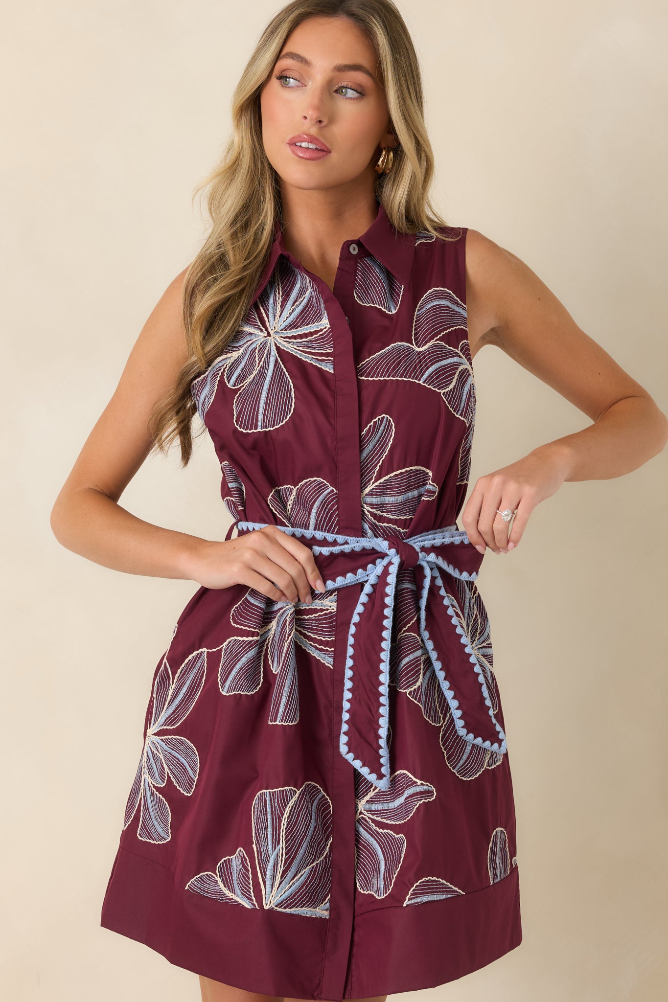Burgundy mini dress highlighting the classic collar, concealed button-front placket, and intricate floral embroidery across the bodice.