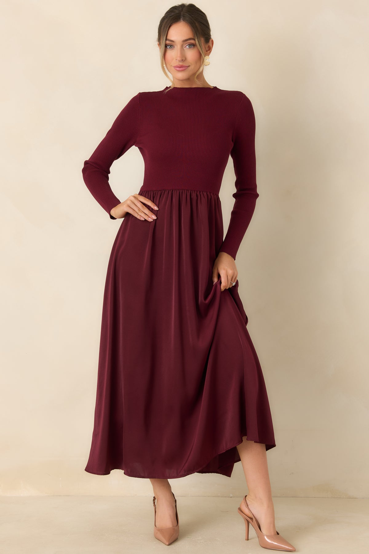 Rich burgundy dress featuring a subtle mock neckline, fitted long-sleeve top, and softly gathered waist.