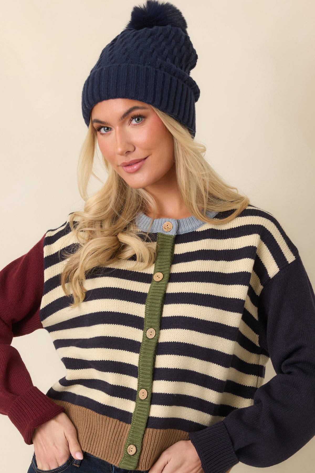 Burgundy and navy color-block sleeves extend from the striped body of the relaxed knit cardigan.