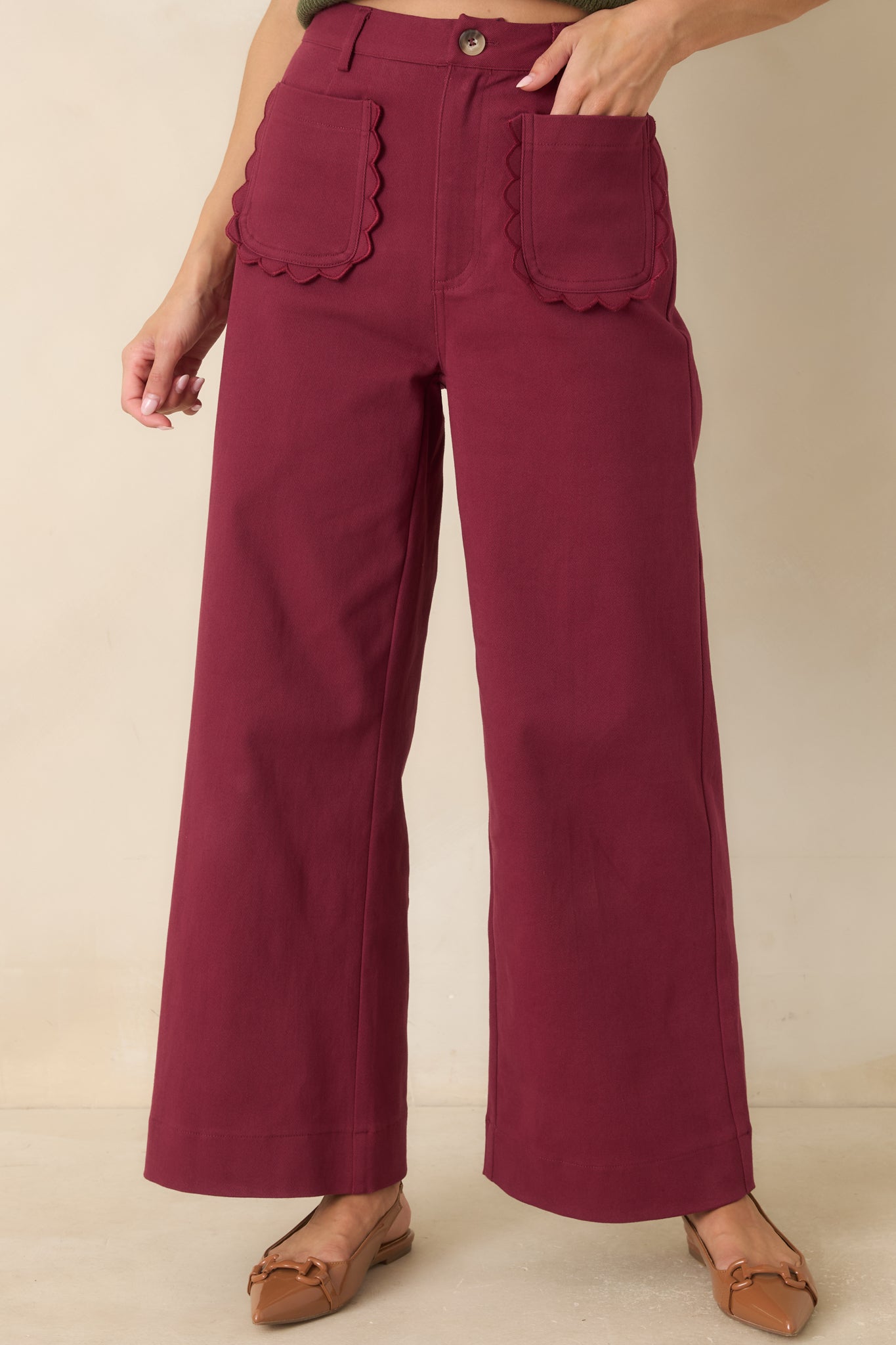 Front detail of the wide-leg pants showcasing the smooth fabric, tailored seams, and button closure.