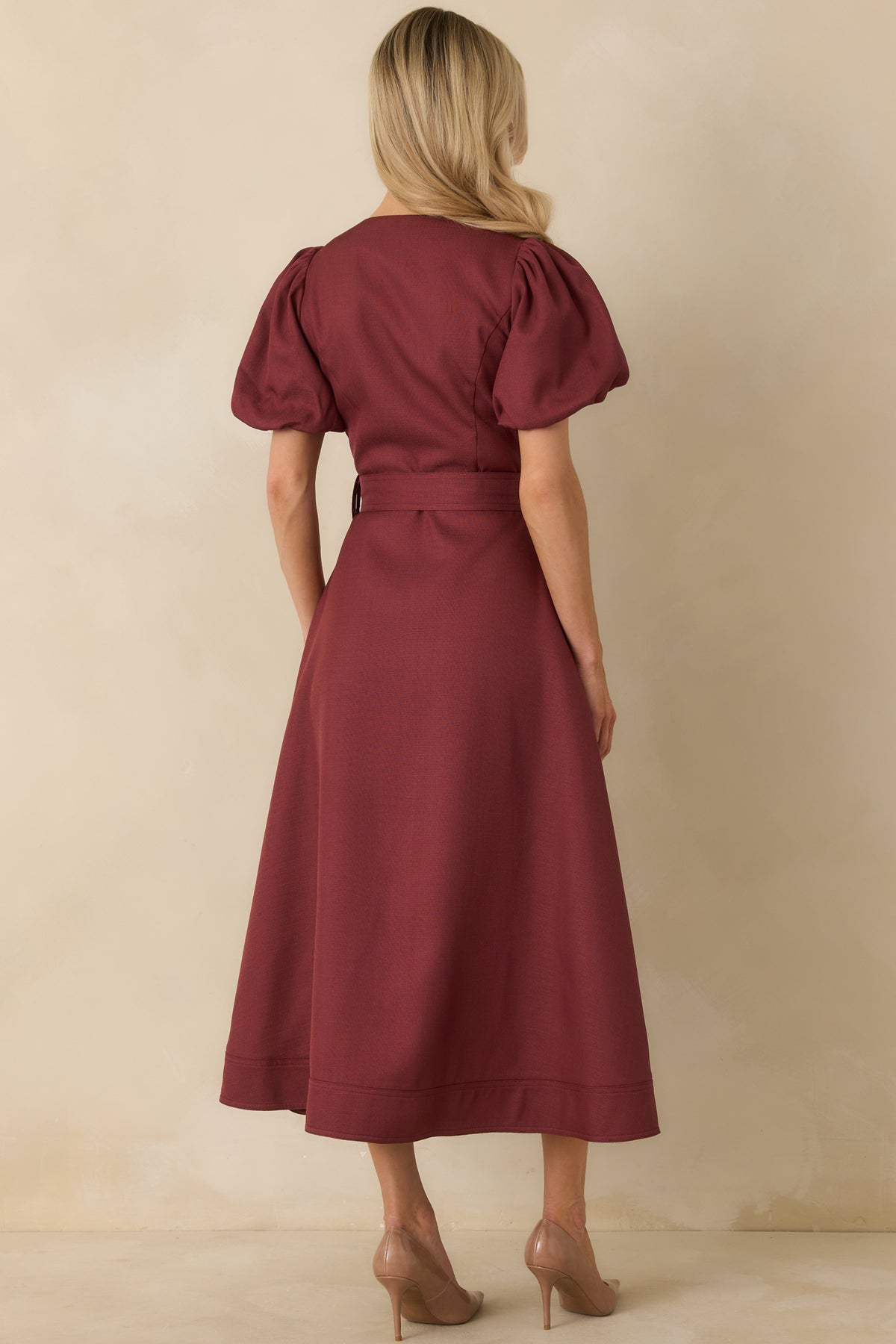 Back view of burgundy midi dress with structured puff sleeves, a fitted waist with removable belt, and flared A-line skirt.