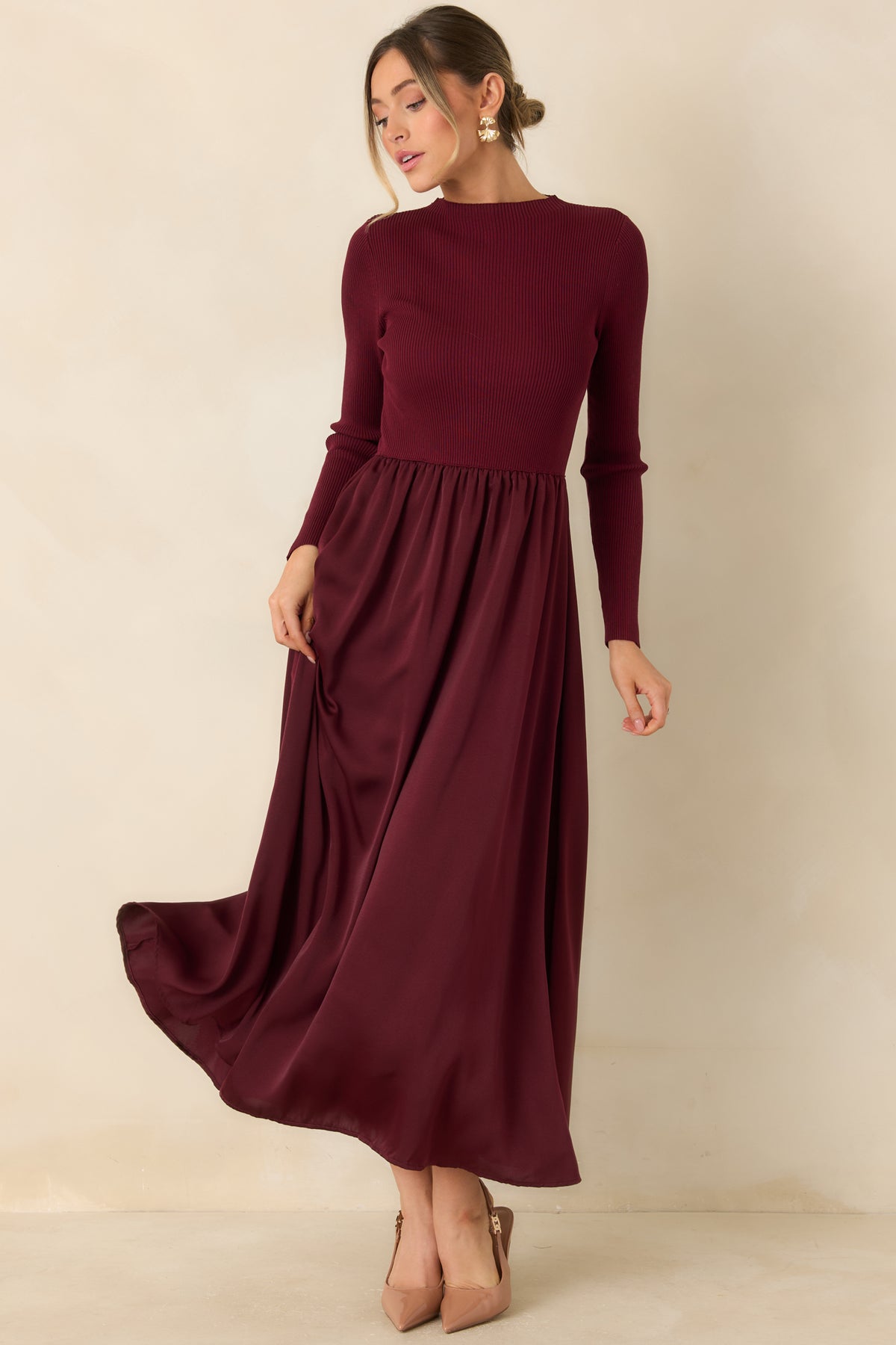 Burgundy seasonal dress with long ribbed sleeves, a fitted waist, and a softly draped satin skirt.