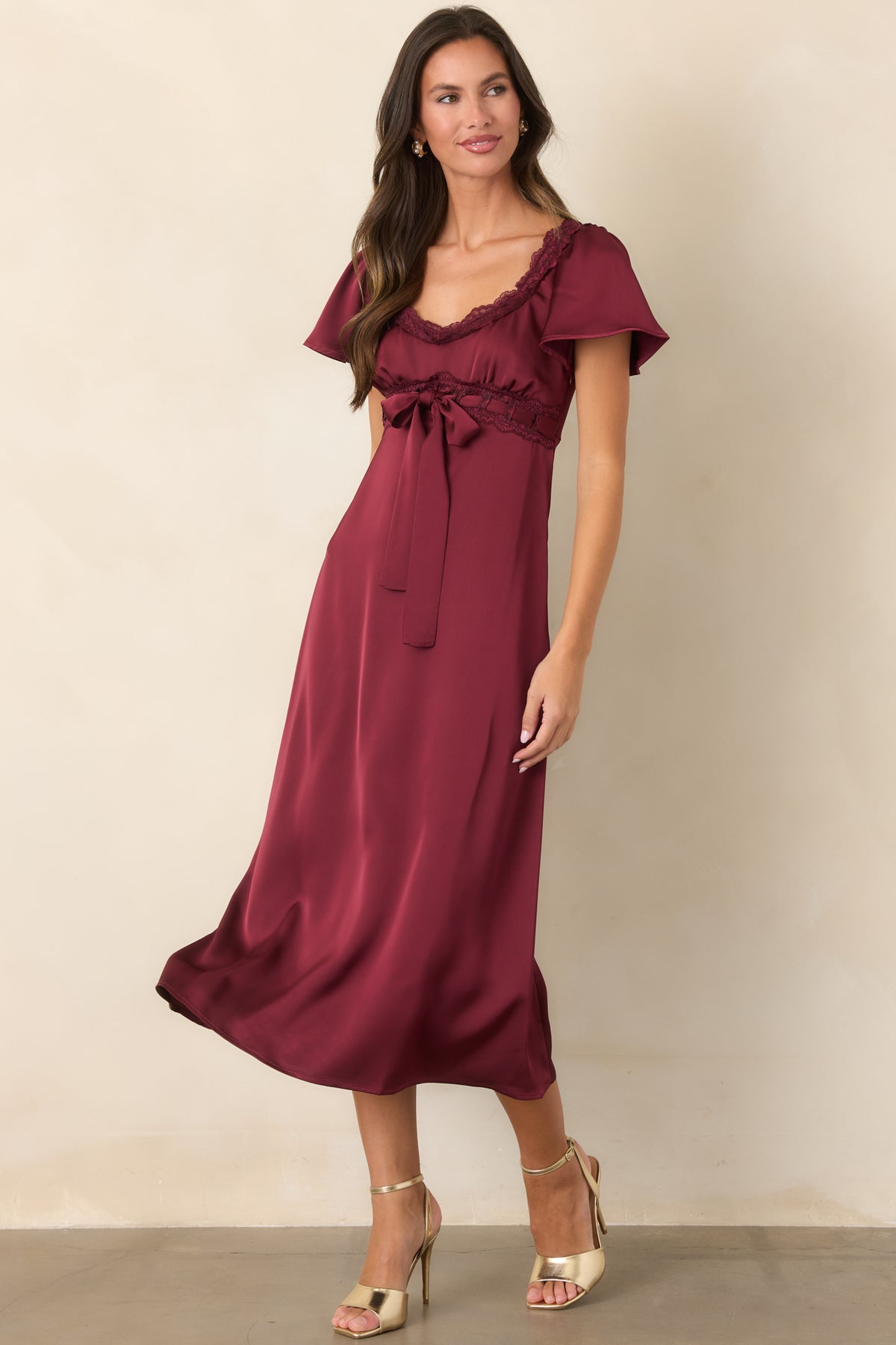Satin burgundy midi dress with a softly gathered bodice, scalloped lace accents, and a flared skirt.