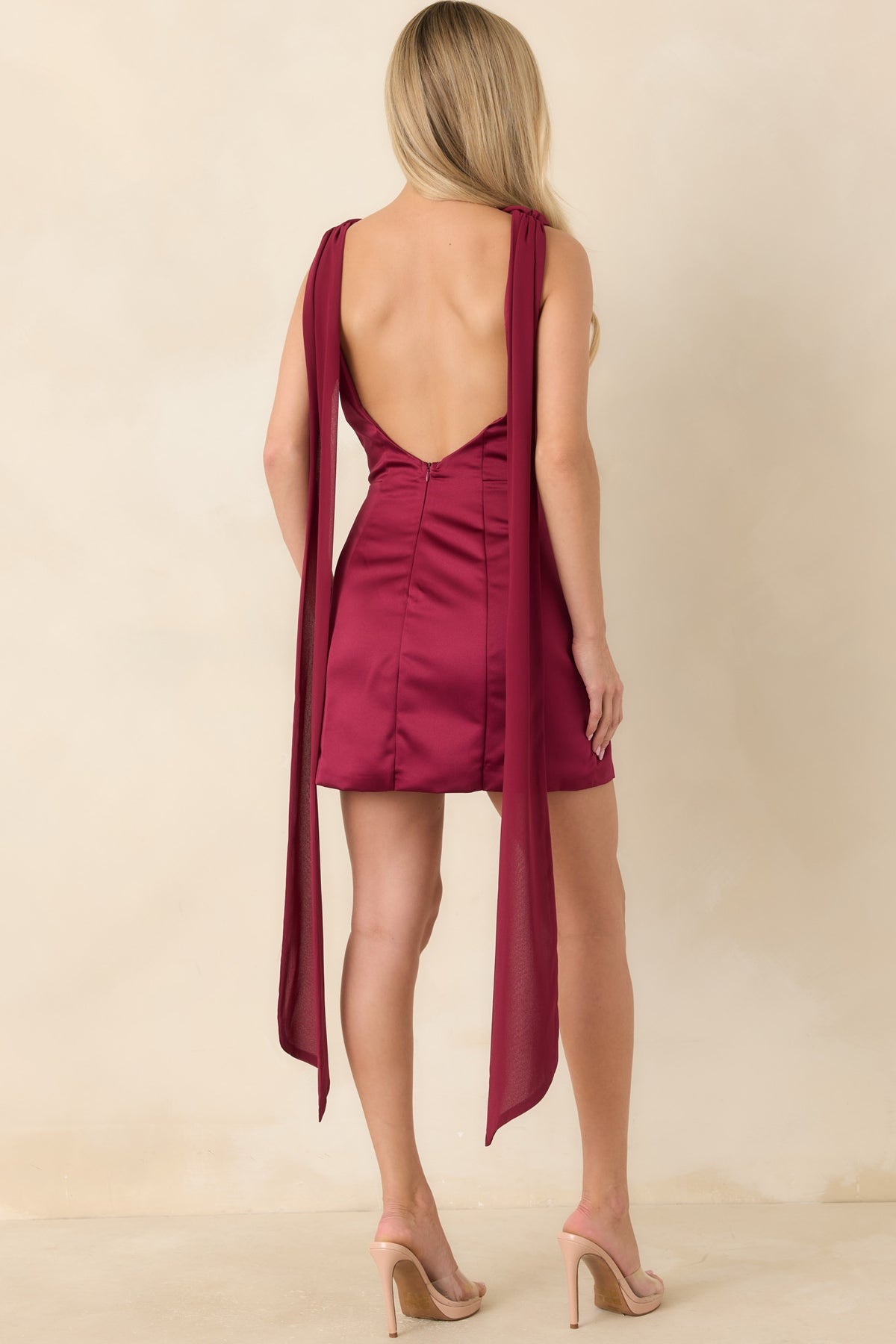 Burgundy satin mini dress with a dramatic low open back, center back zipper, and vertical seam detailing.