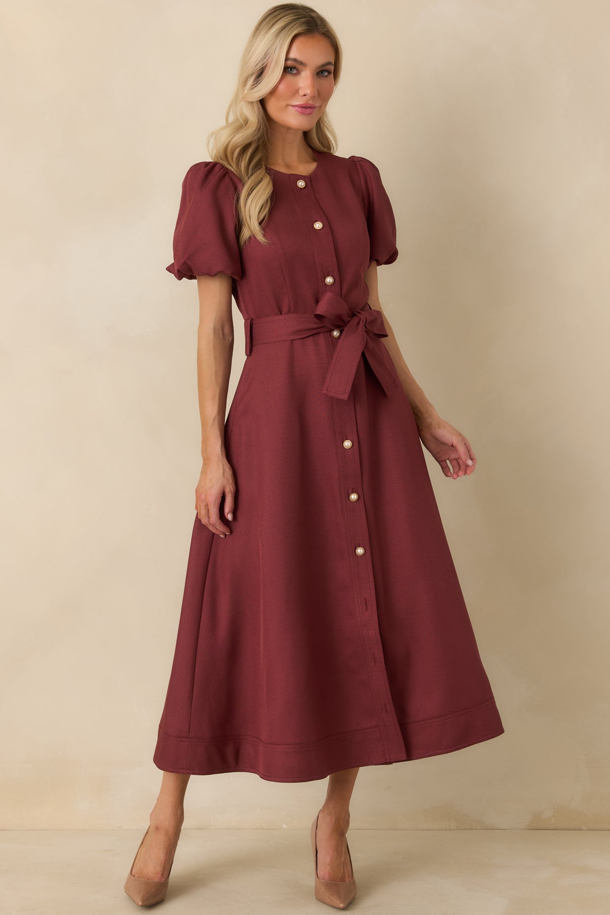 Structured burgundy midi dress featuring a defined waist, self-tie belt, full button front, and softly flared skirt.