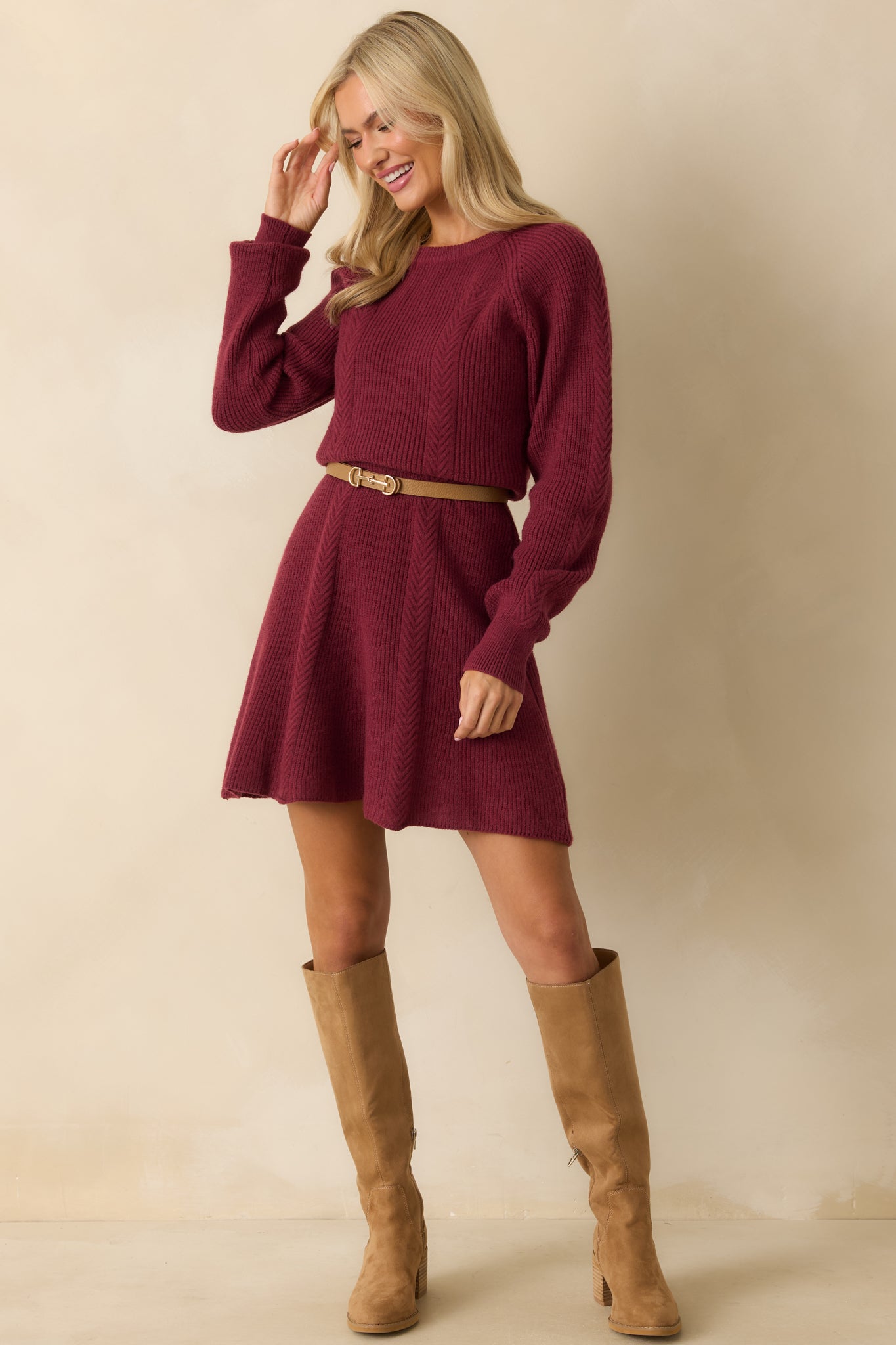 Burgundy ribbed sweater dress with a figure-flattering fitted bodice, ribbed cuffs, and flowing hem for movement.