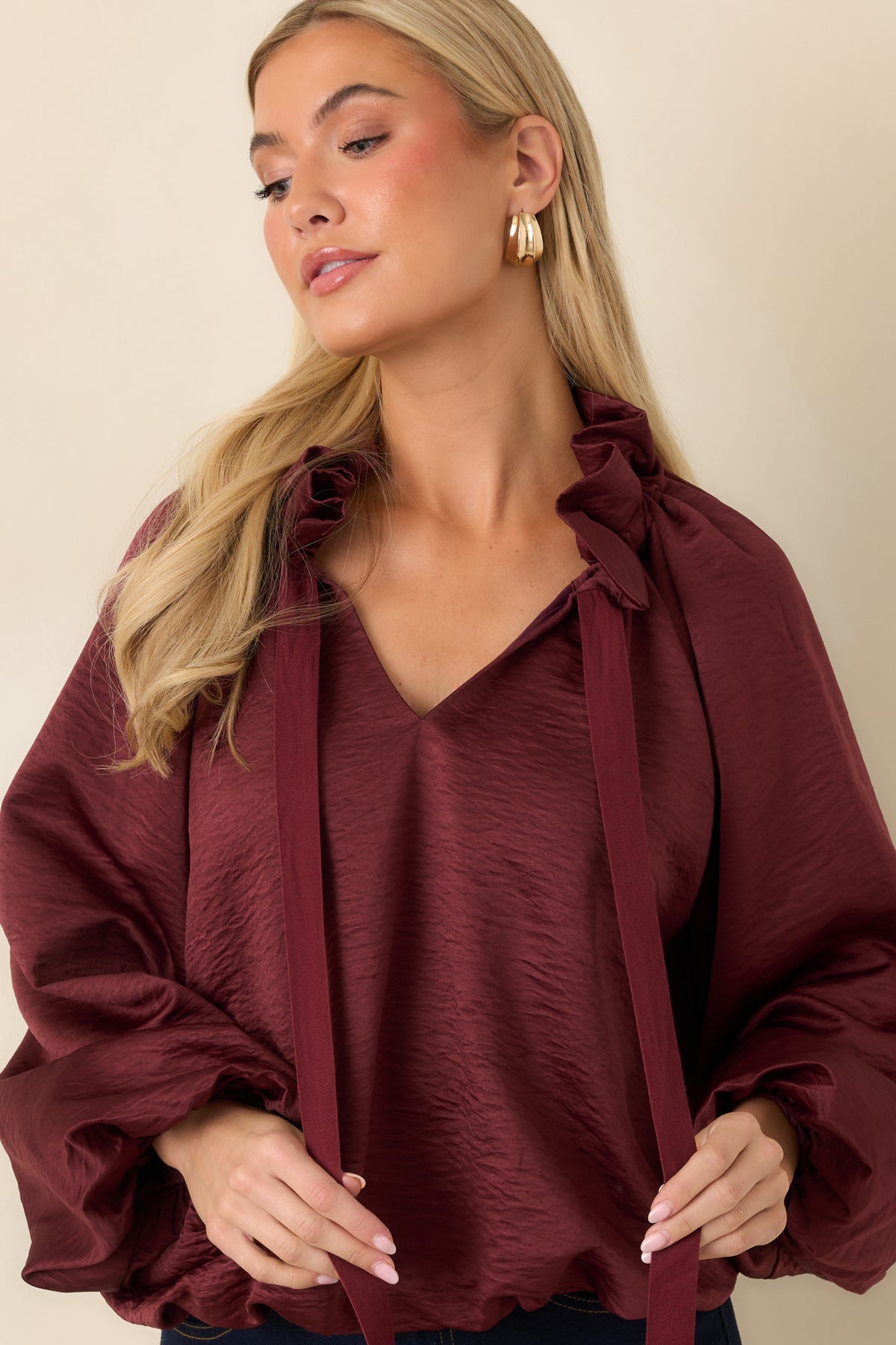 Long burgundy neckline ties drape over the softly crinkled fabric and can be knotted into a bow.