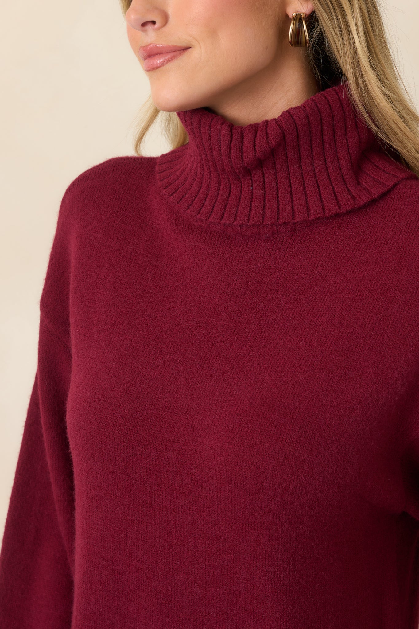 Close-up of the burgundy sweater dress highlighting the soft ribbed knit texture, turtleneck neckline, and cozy stretch construction.
