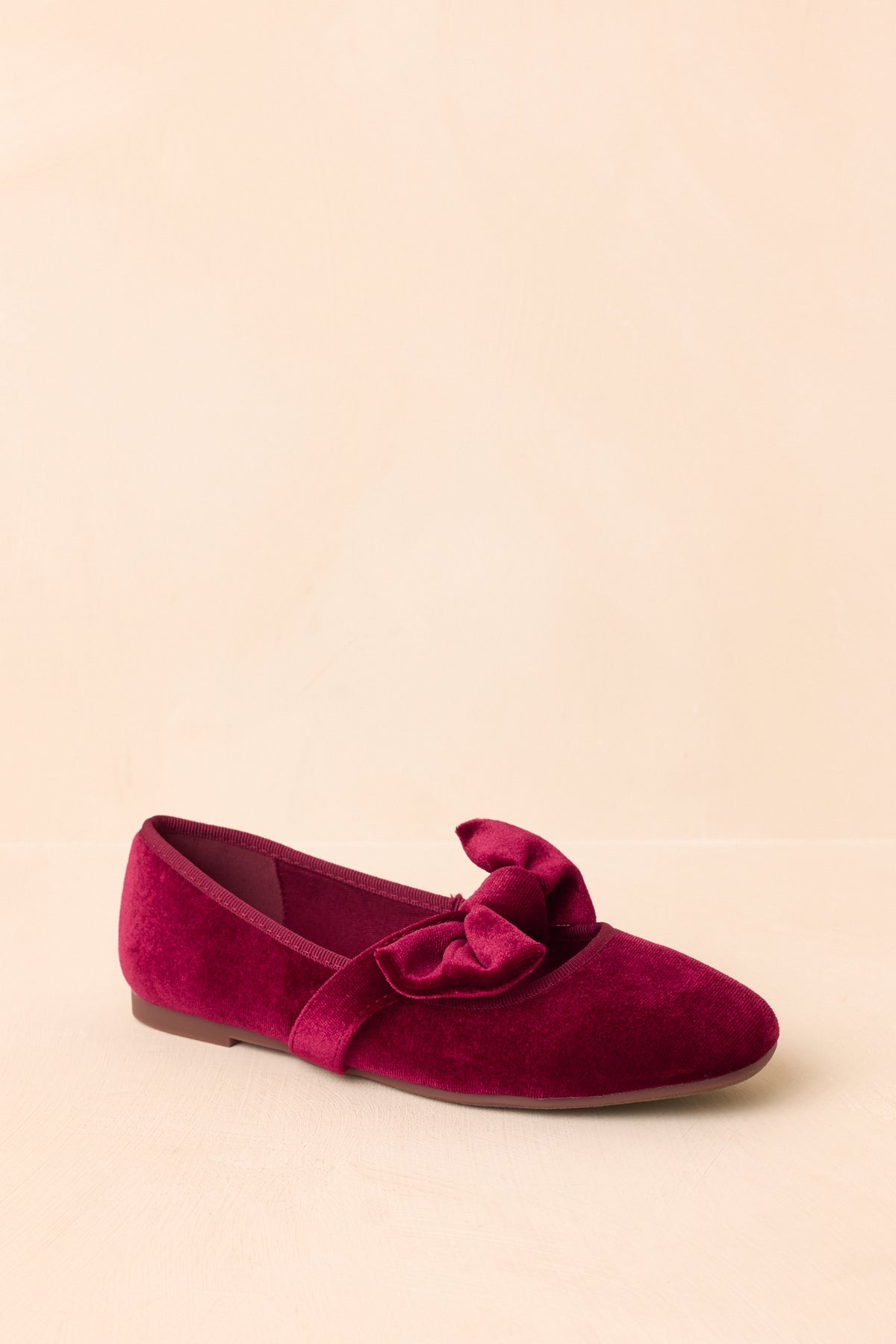 The classic silhouette features tonal trim surrounding the rich burgundy velvet upper.