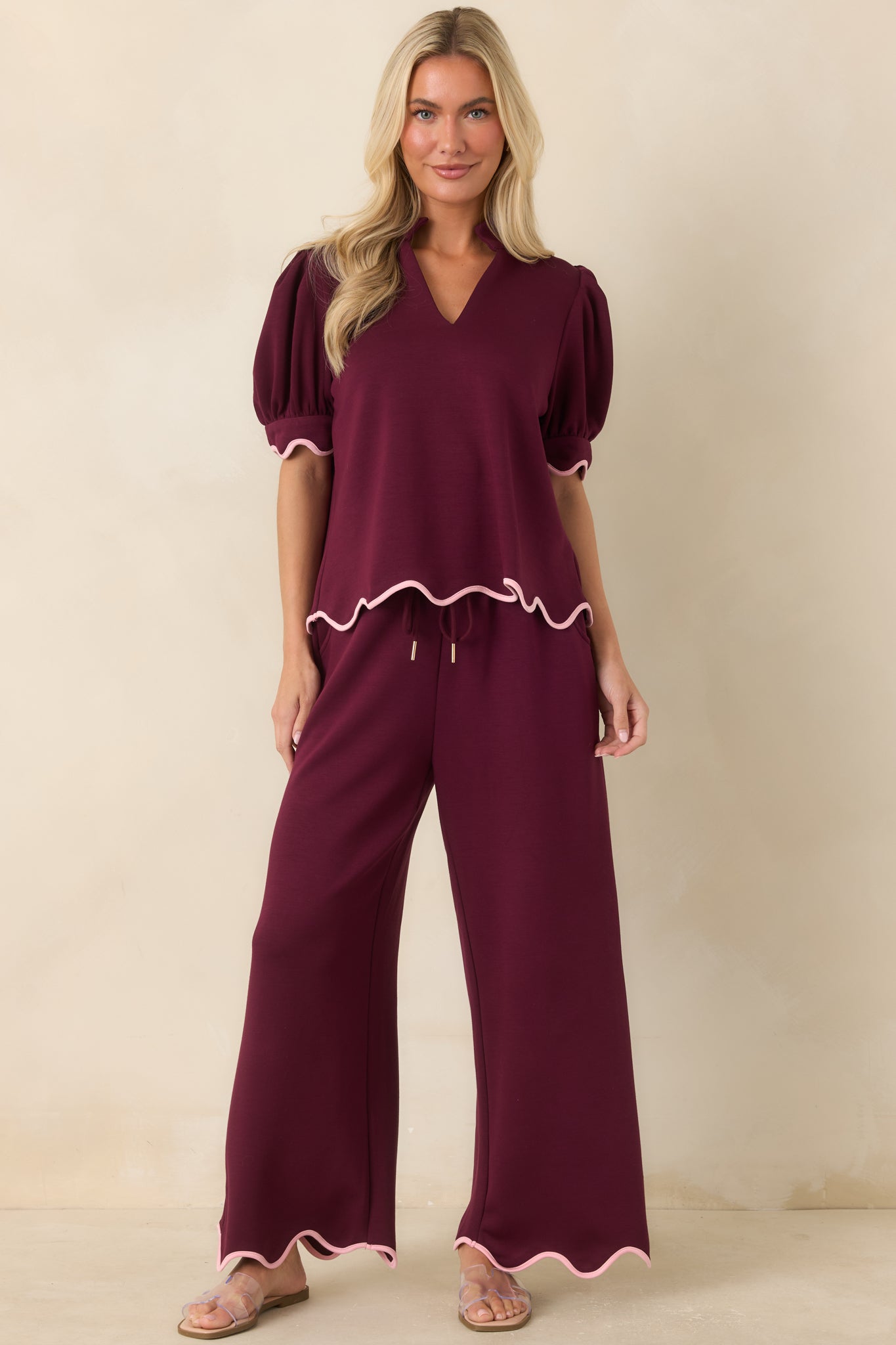 Burgundy wide leg pants highlighting the adjustable waistband and gold-tone cord ends for an elevated finishing touch.