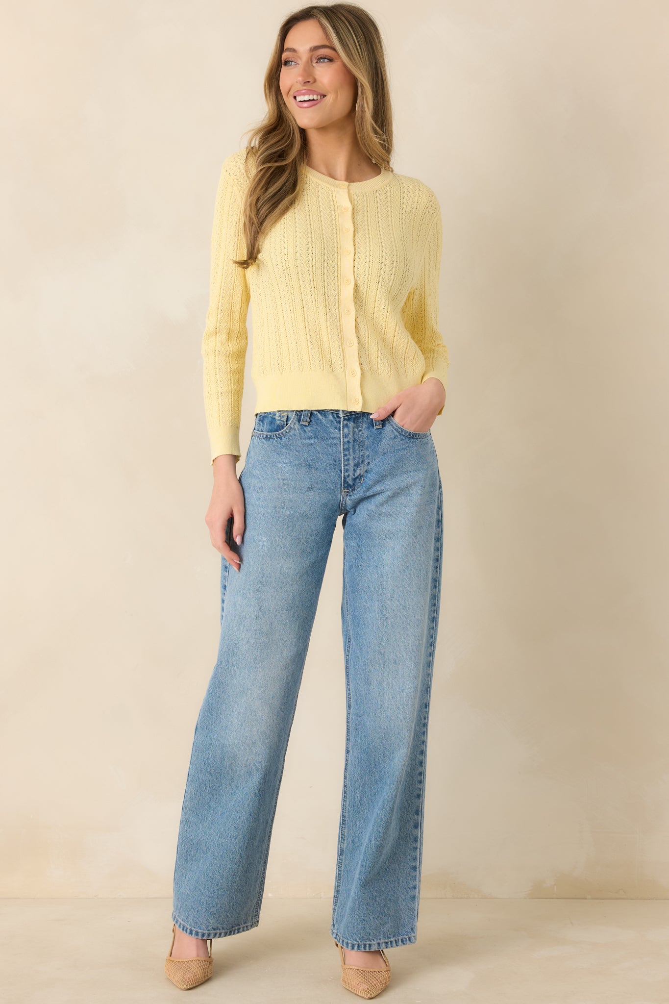 Front view of a butter yellow pointelle knit cardigan with airy eyelet detailing and button-front closure.