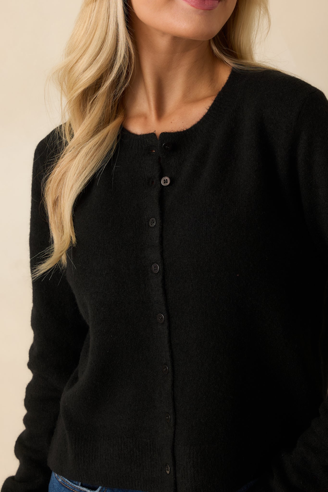 Detailed view of the button closure showcasing the knit texture and polished finishing.