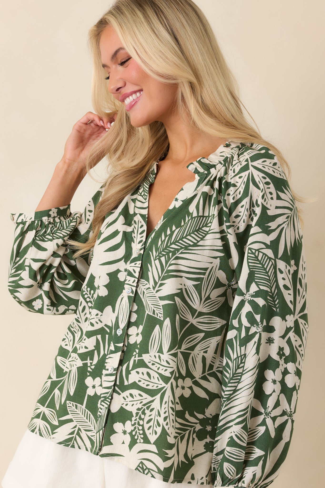 Front cropped detail emphasizing long button-cuffed sleeves and vibrant tropical pattern