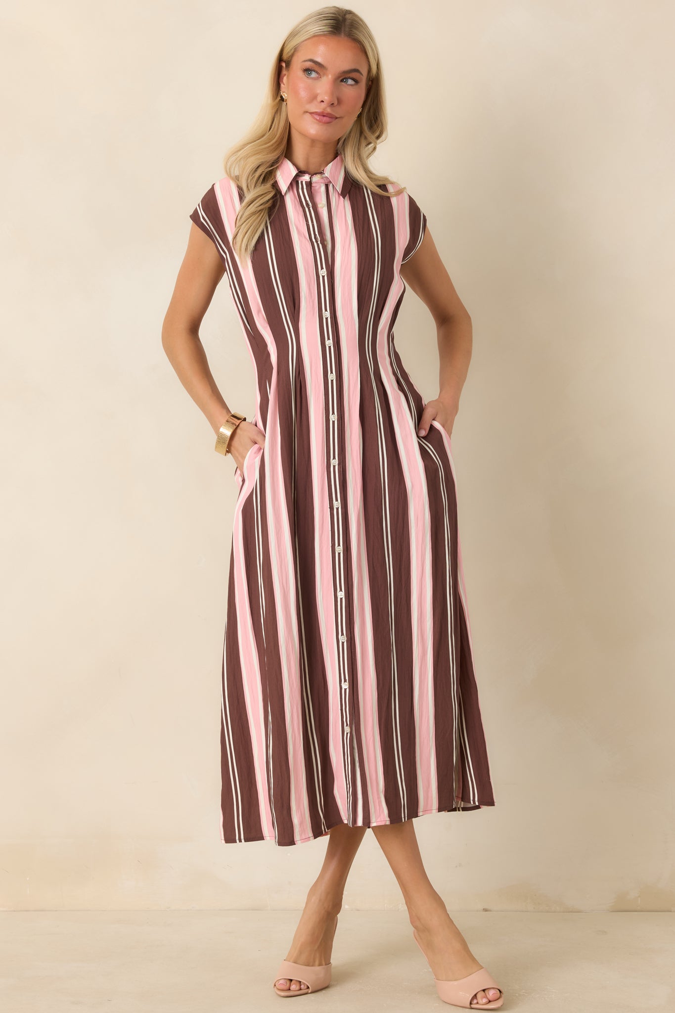 Fit-and-flare midi dress designed with a full button front, cap sleeves, and flattering striped silhouette.