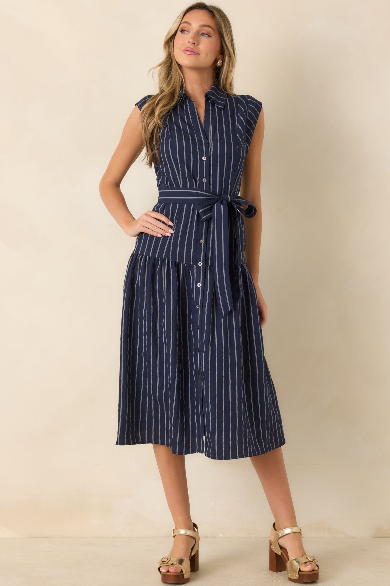 Polished striped midi dress featuring a full skirt, button-front design, waist-defining tie, and lightweight fabric.