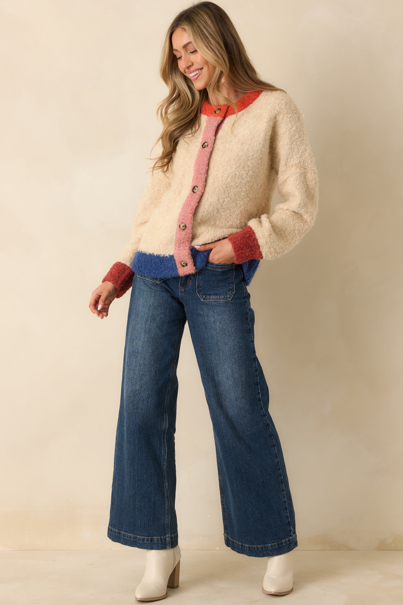The buttoned front and color block design show the cozy texture and layered-ready shape