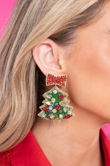Model is shown wearing earrings that feature a fun beaded Christmas tree design, a felt back, red and green rhinestones, and a secure back fastening.