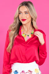 Front view of this top that features a collared neckline, v-neckline, buttons down the front, cuffed sleeves, and a high low style.