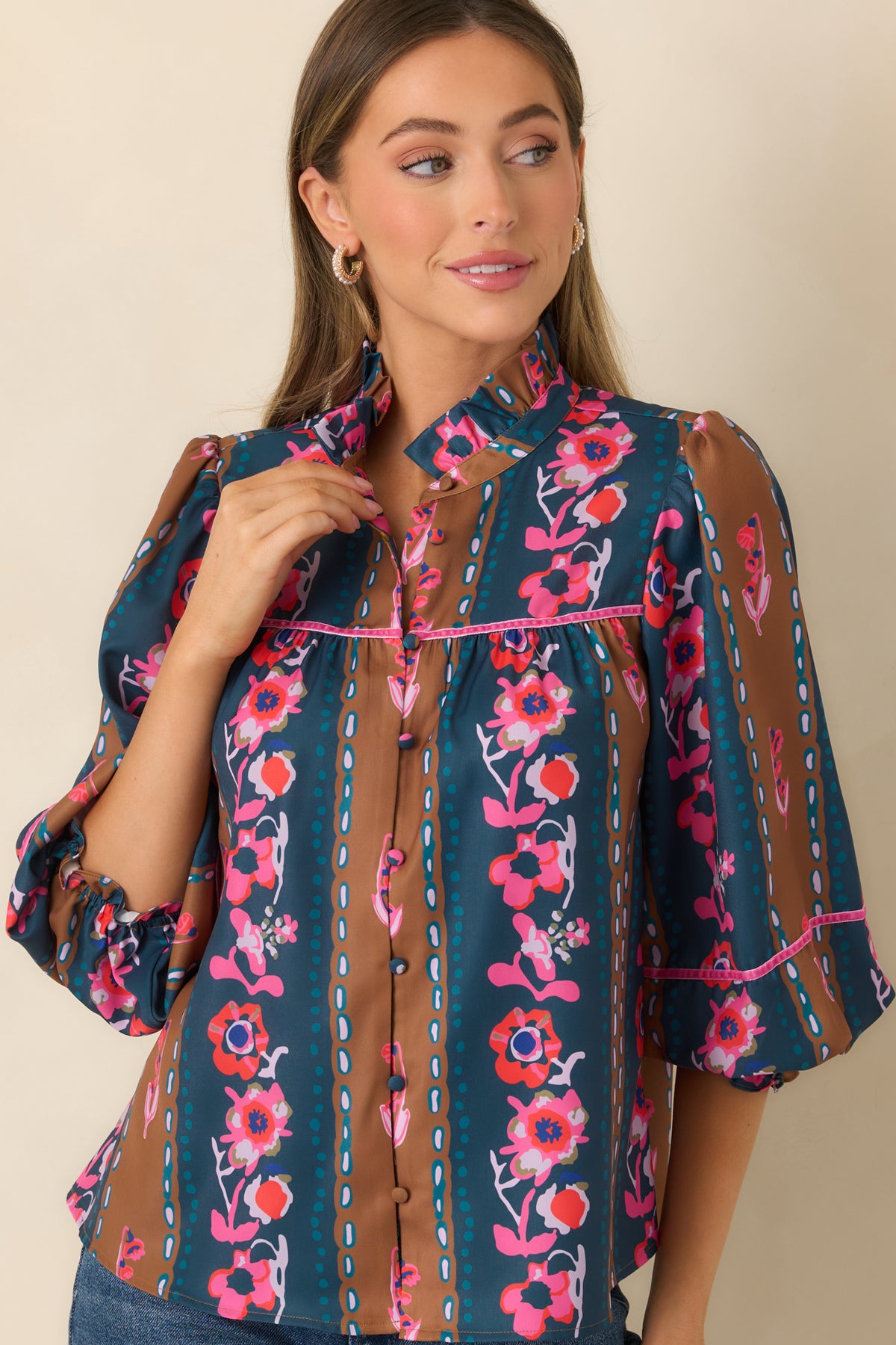 Pink trim outlines the front yoke of the CROSBY blouse against deep teal and caramel stripes.