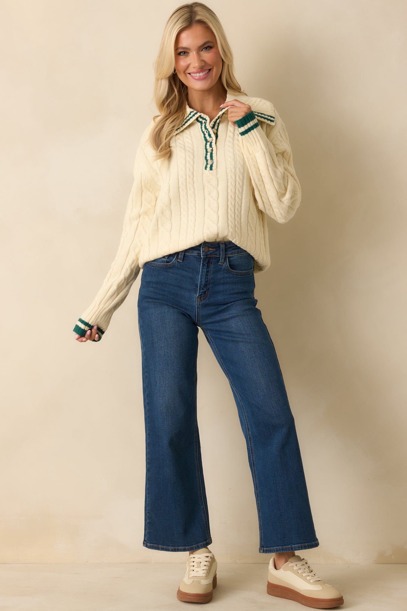 Cable knit ivory sweater with long sleeves, collared neckline, and relaxed fit finished with ribbed cuffs and hem.