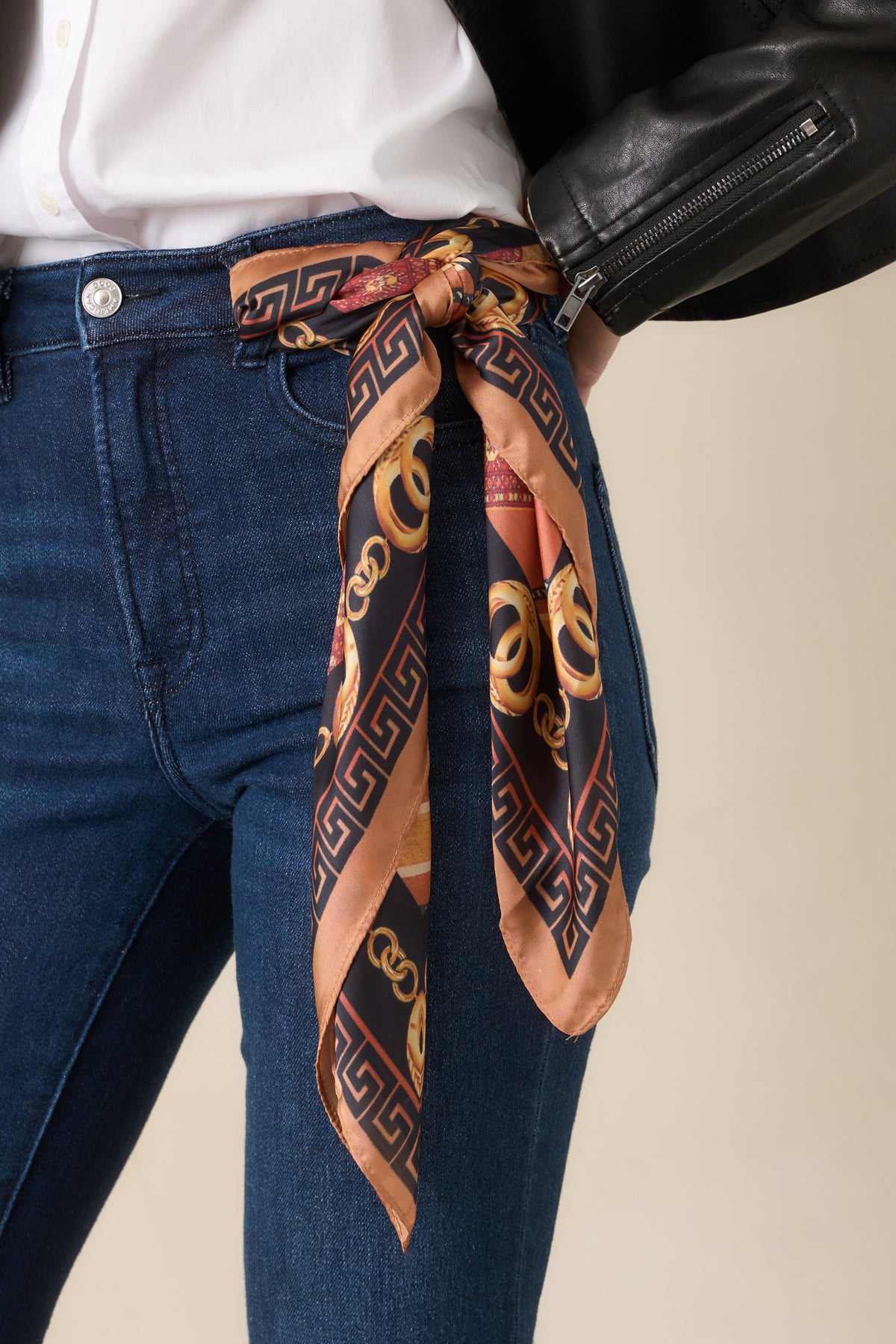 Square polyester scarf featuring ornate golden chain motifs, patterned stripes, and a Greek key border in camel, black, rust, and burgundy tones.