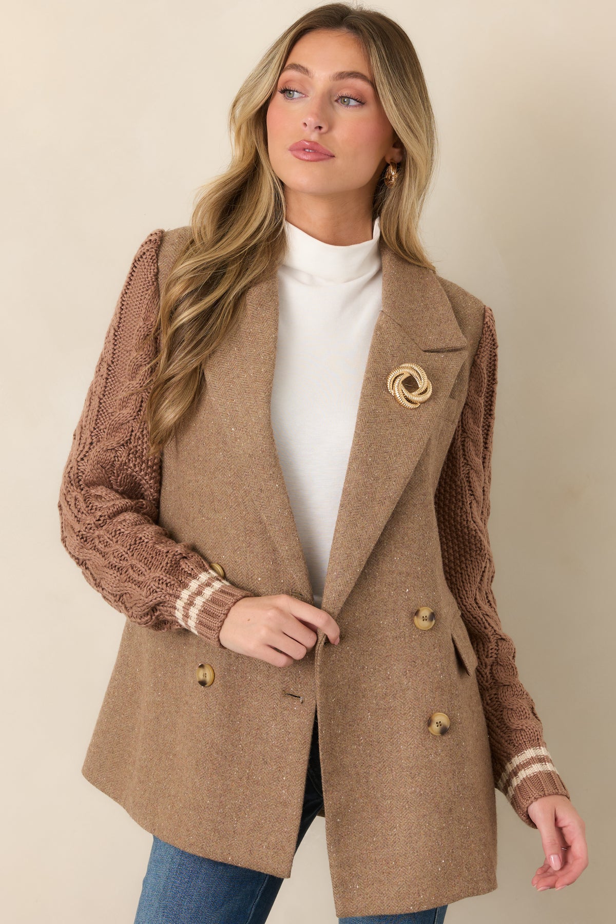 Close view of the camel blazer’s notched lapels, double-breasted button closure, and structured wool-blend fabrication.