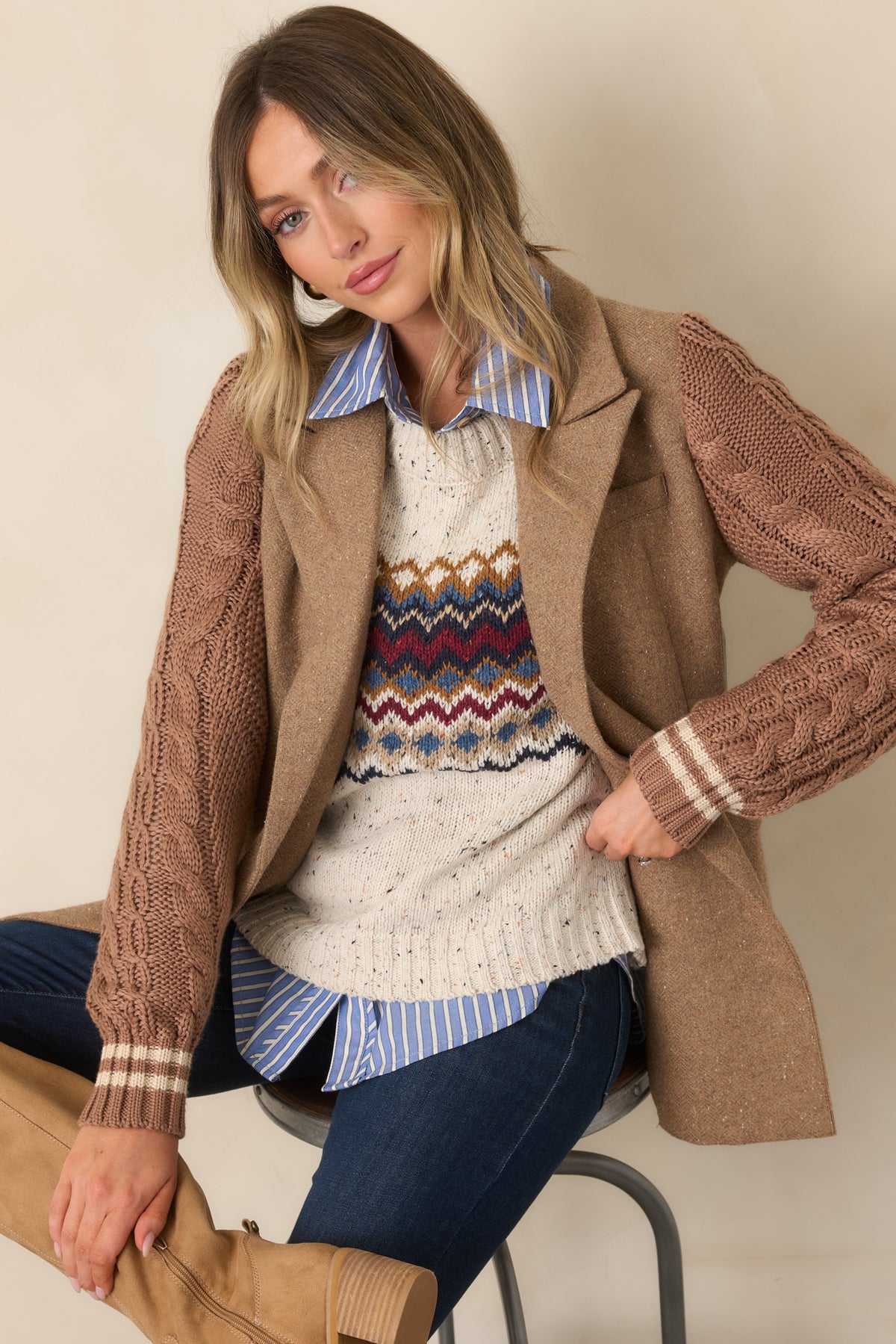 Camel blazer showcasing the notched lapels, double-breasted button arrangement, and textured cable-knit sleeve construction.