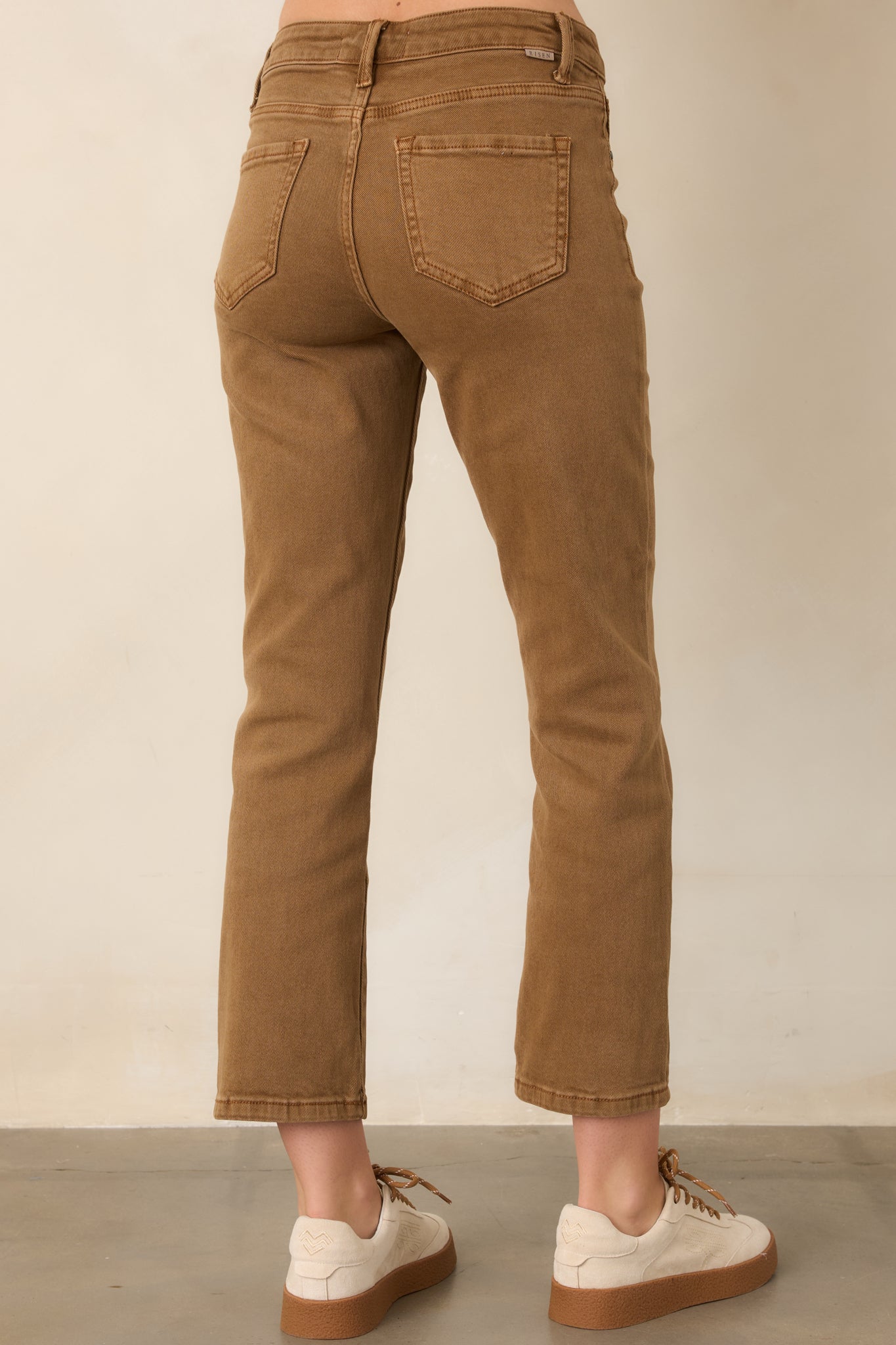 Rear view of the camel brown cropped denim pants, showcasing the mid-rise waistband, back pockets, straight-leg shape, and cropped hems.