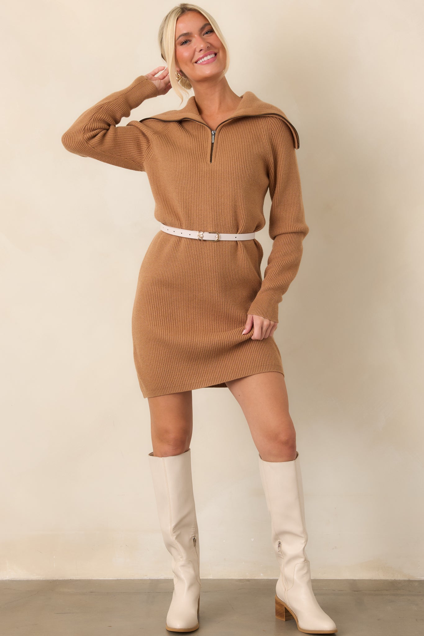 Camel brown knit mini dress featuring vertical ribbing, a half-zip funnel collar, long sleeves, and a relaxed longline fit.