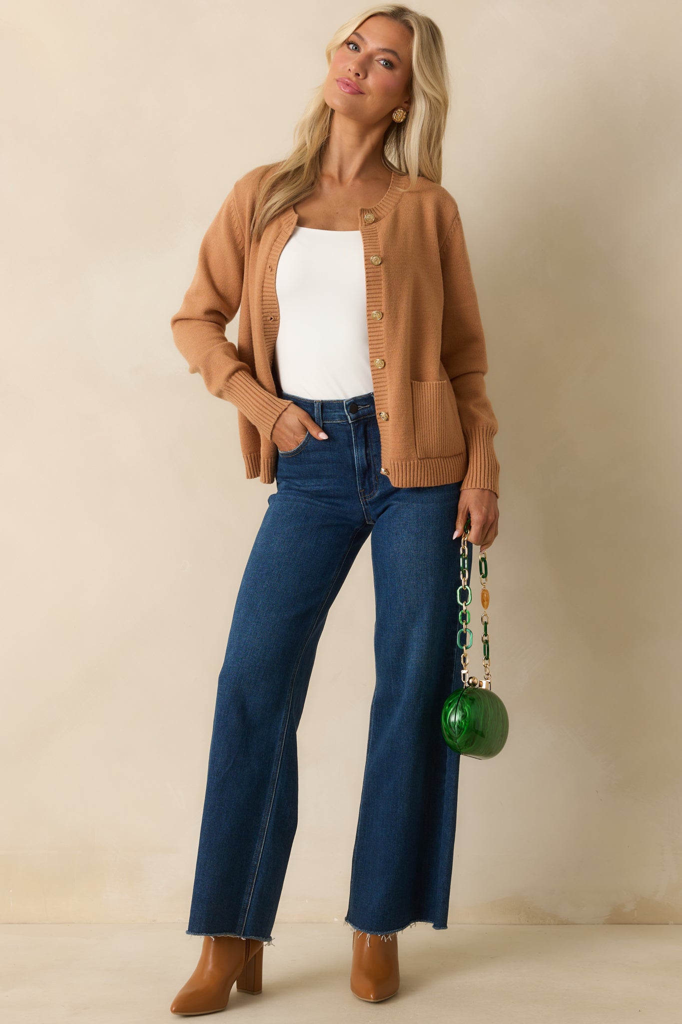 A full-length view of the camel cardigan showing long sleeves and patch pockets.
