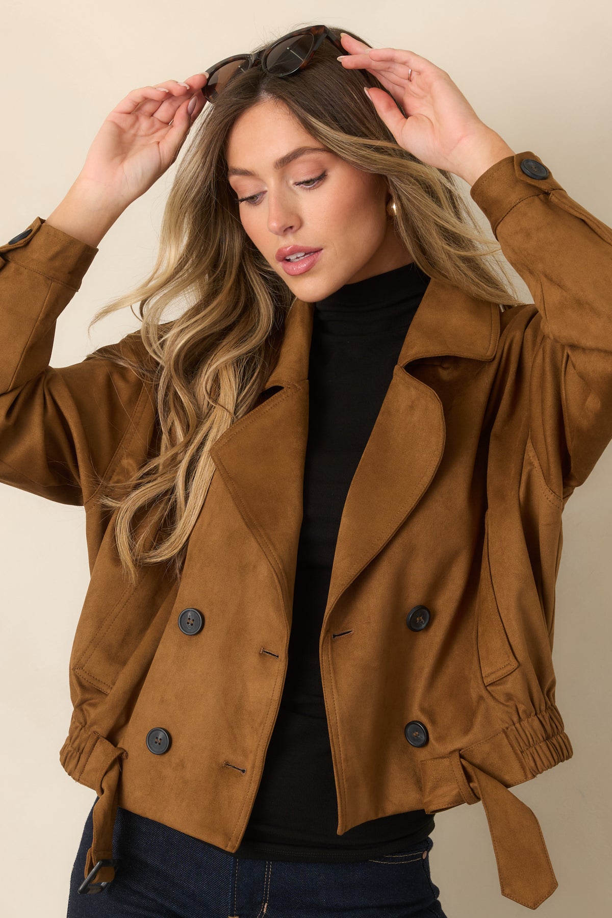 Camel cropped trench coat showcasing the belted waist and elasticized hem.