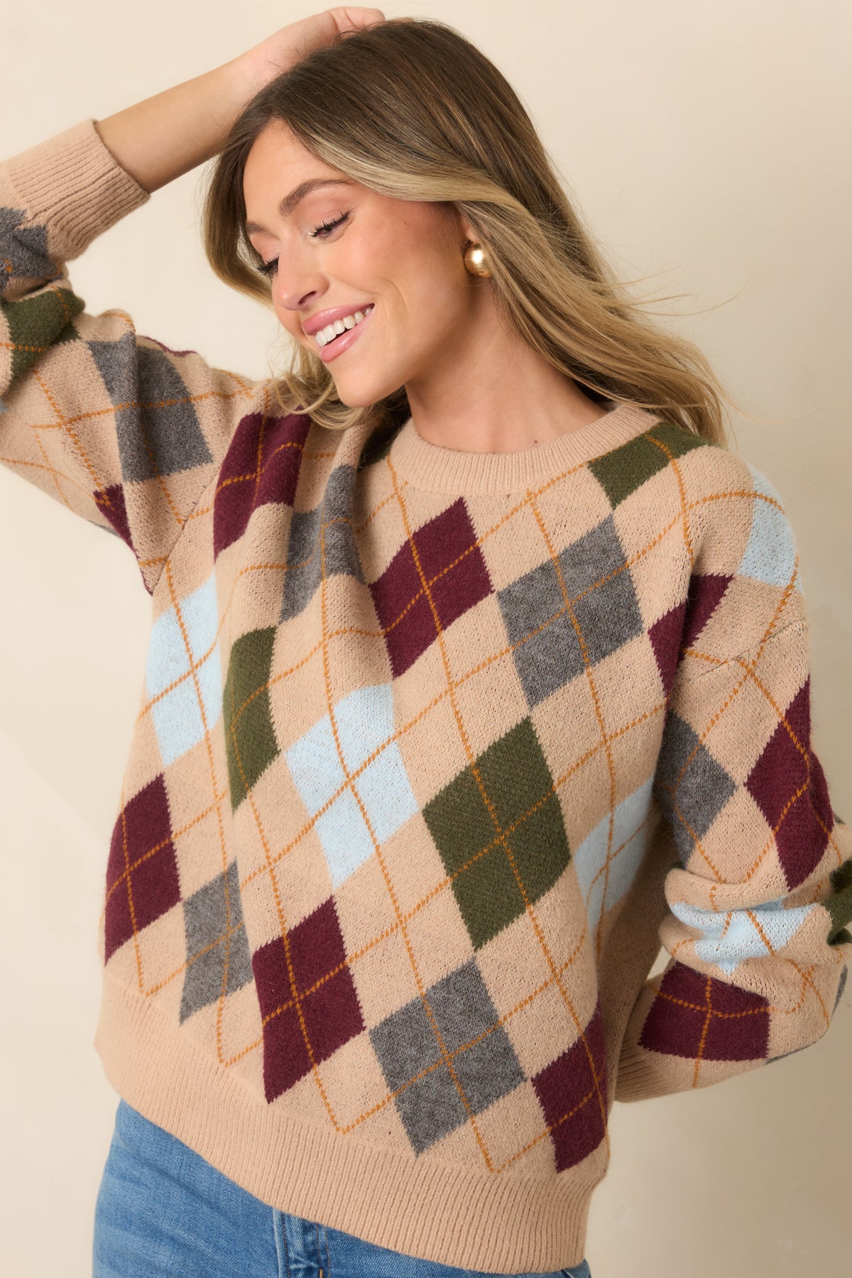 Dropped shoulders and long sleeves create a relaxed silhouette across the patterned camel sweater.